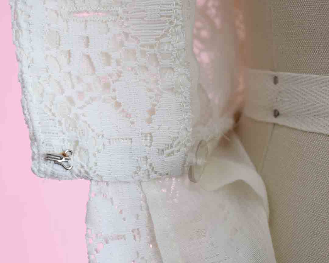 Inside of the waistline of the dress which has a hidden button and hook closure.