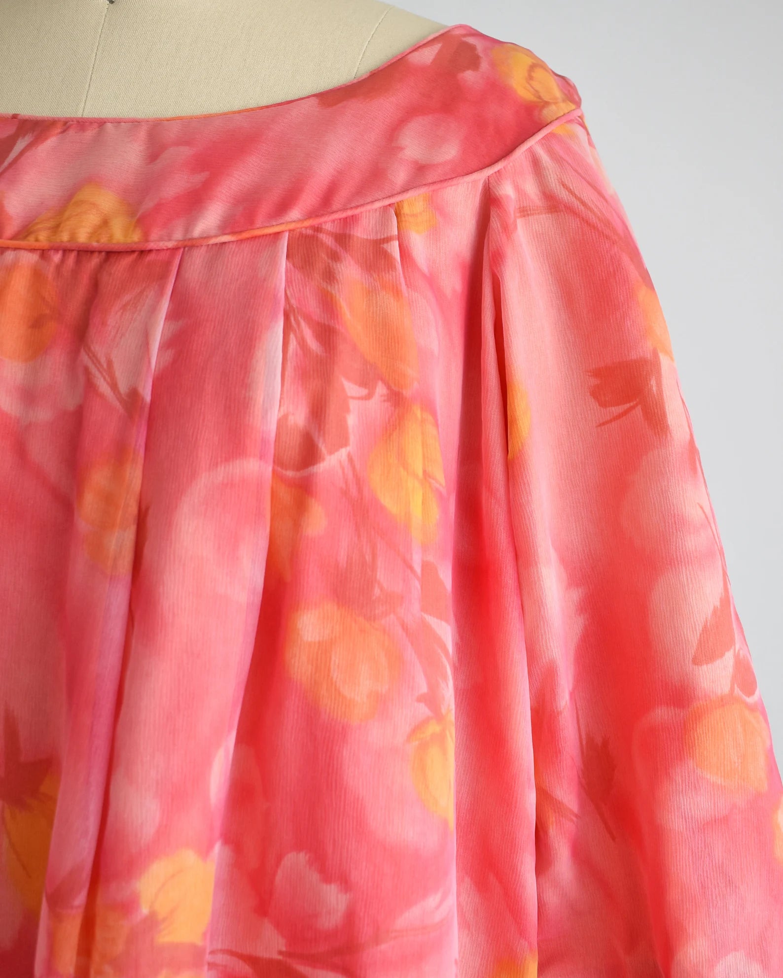 Close up of floral print, which is in yellow, pinks, orange, and dark red.