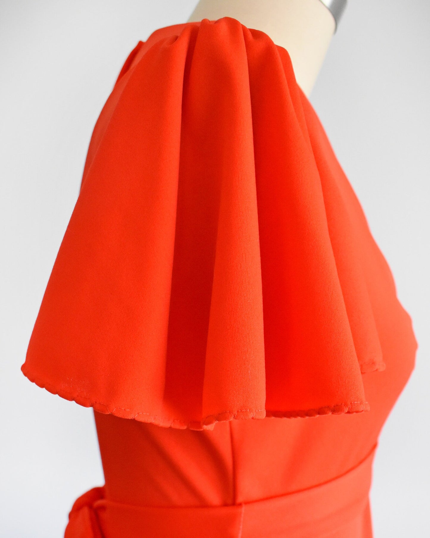 Close up of the short sleeve which features stitched scalloped cuffs.