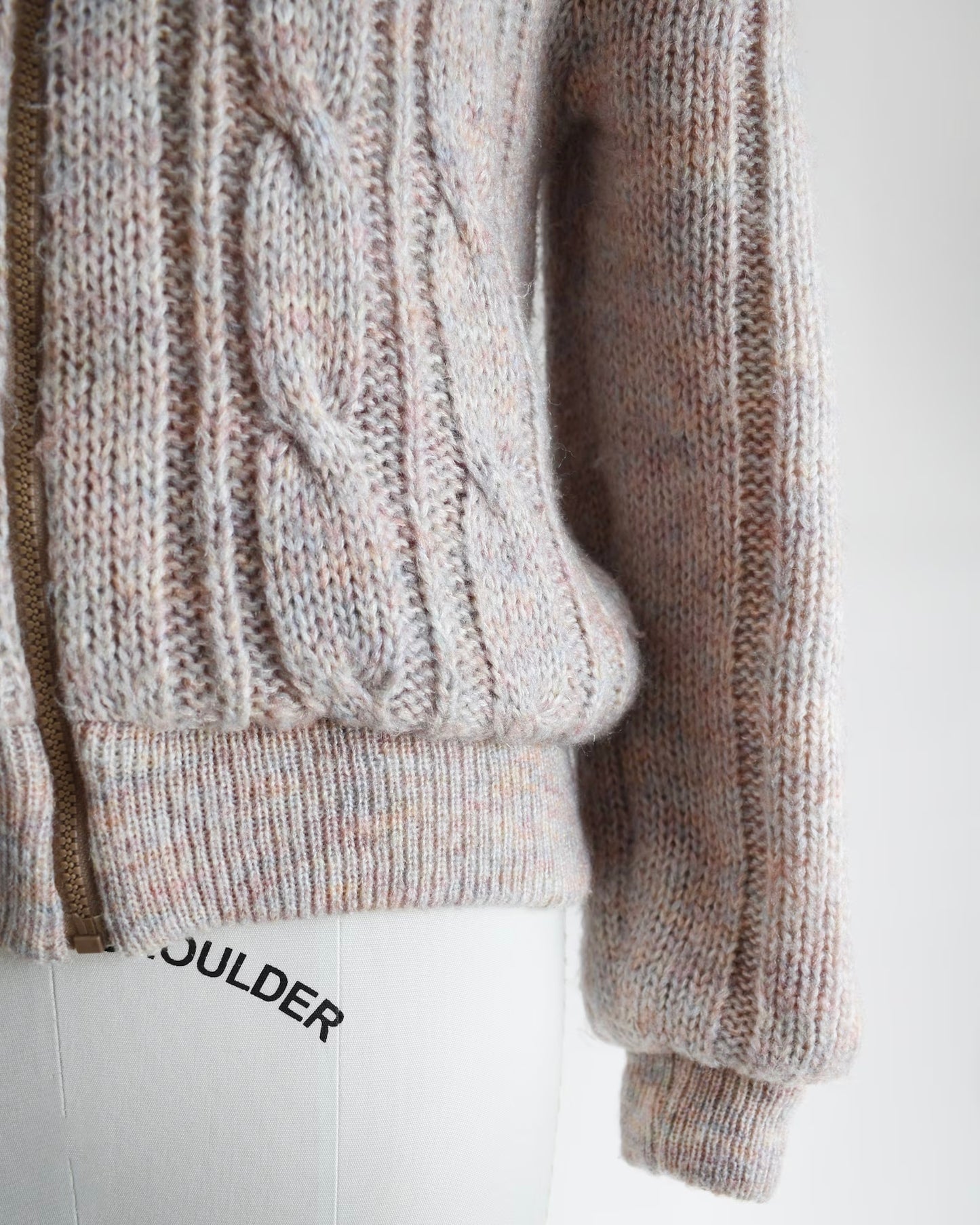 Close up of the waist, cable knit detail, and sleeve