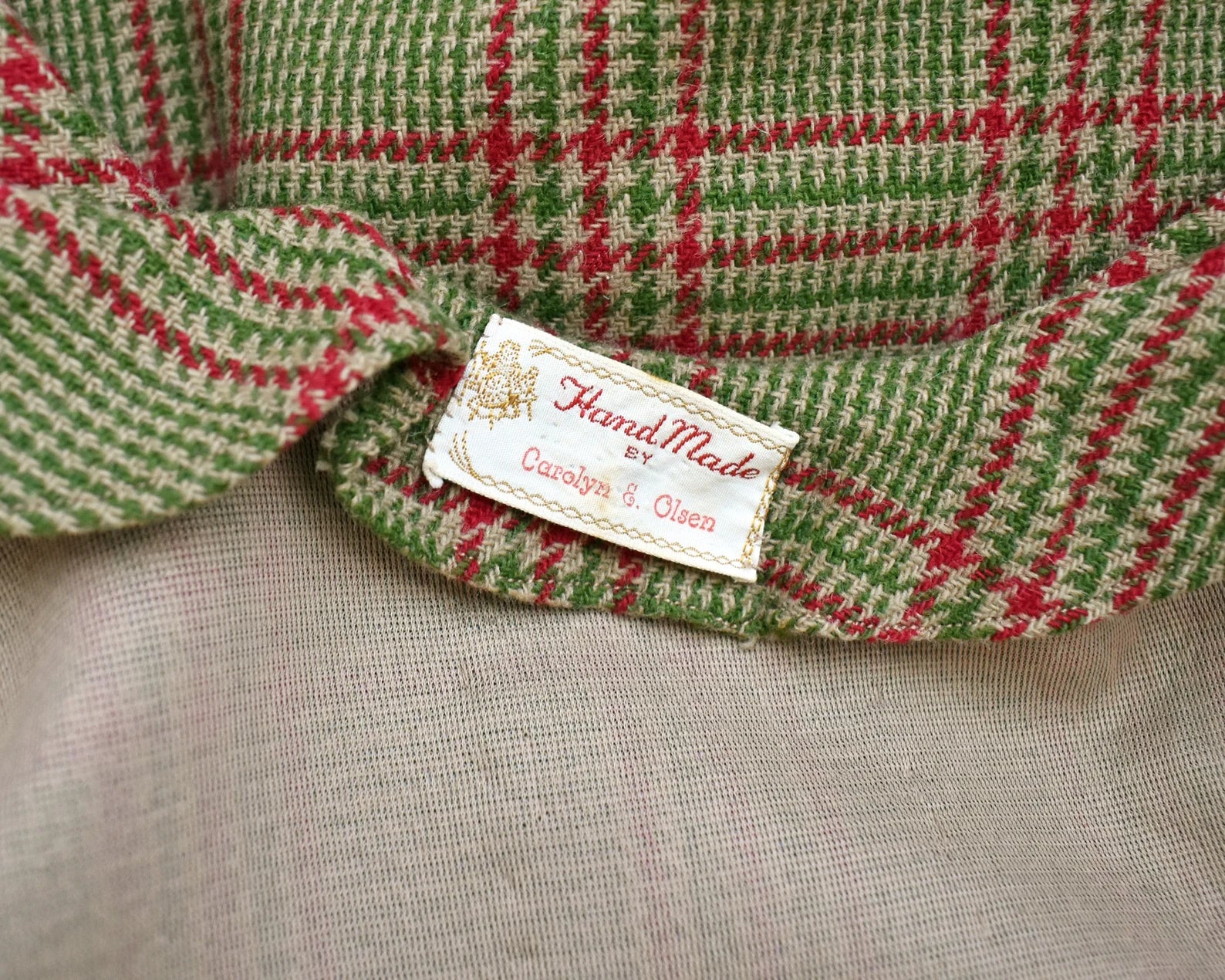 Close up of the tag which says Hand Made by Carolyn E. Olsen