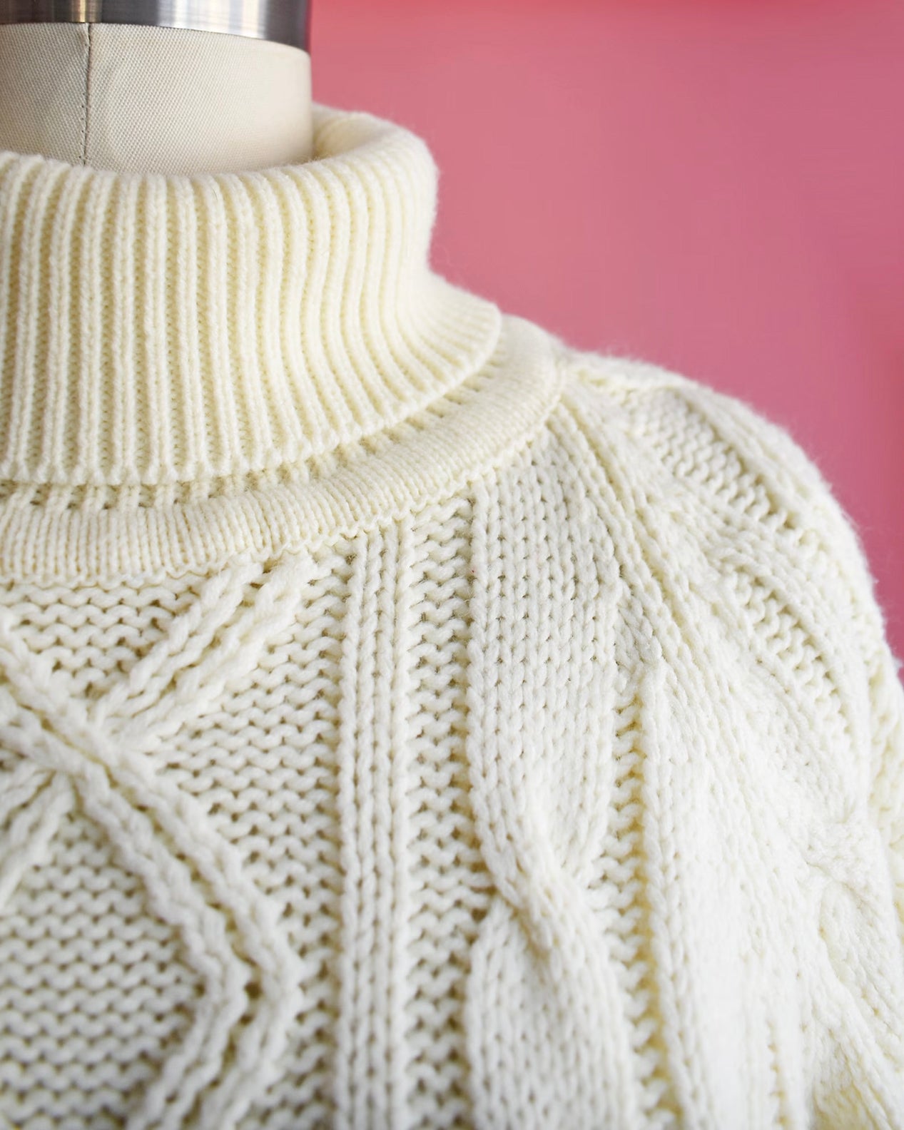 close up of the turtleneck collar and cable knit detail on the shoulder