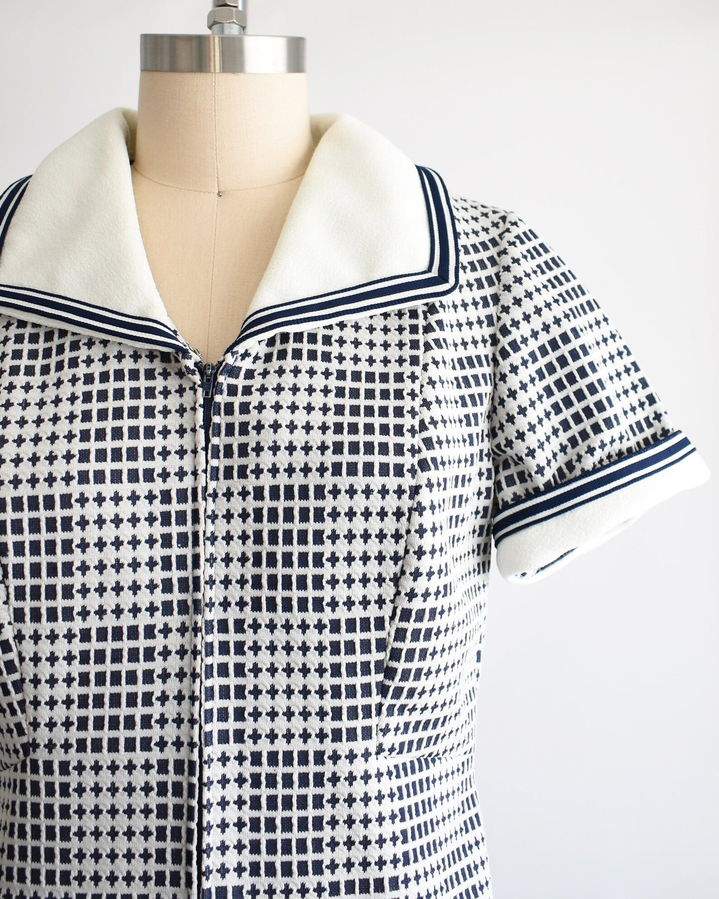 Side view of the bodice of the dress which shows the geometric print, collar, and short sleeves.