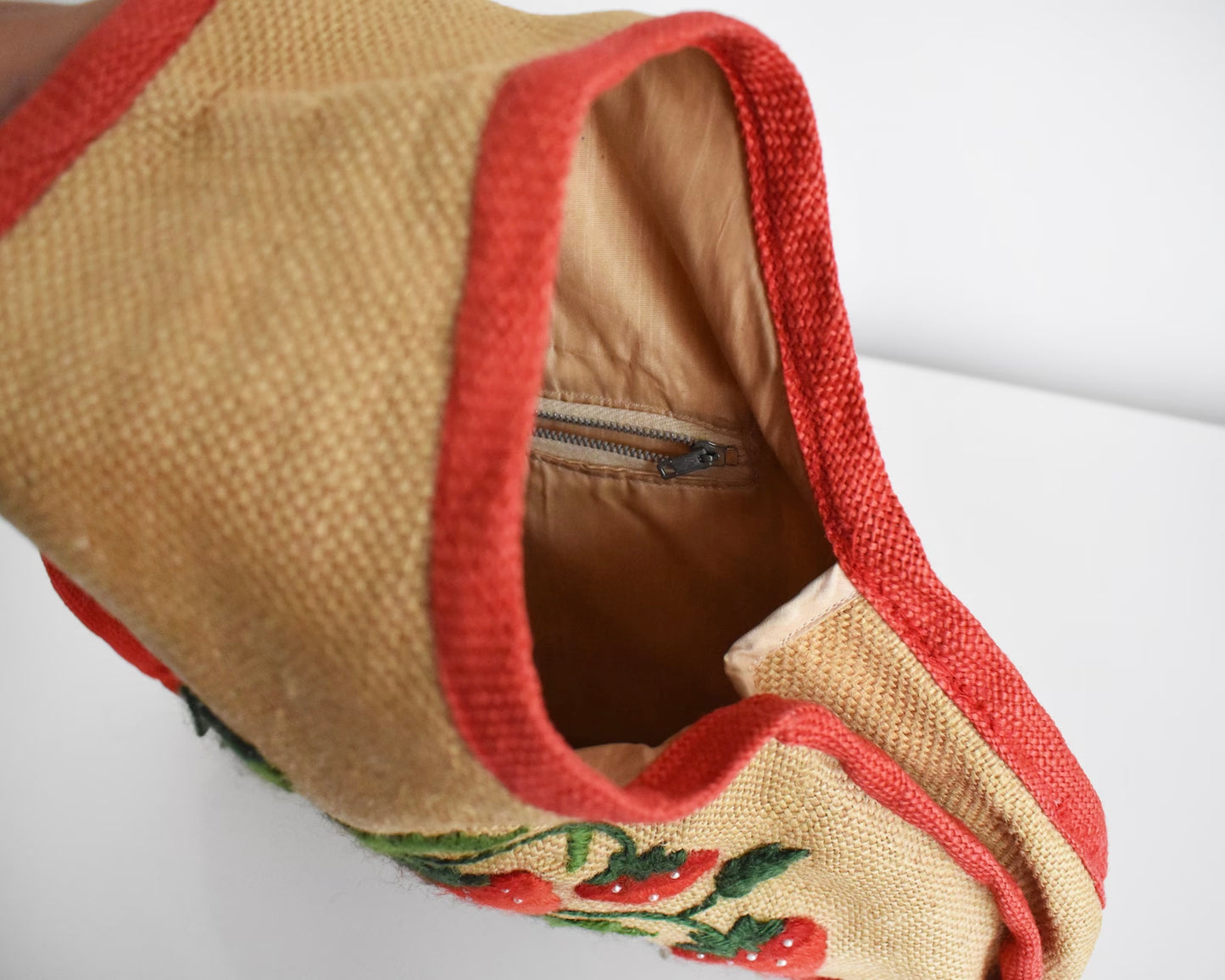 Close up of the inside of the purse that shows the tan lining and zipper pocket