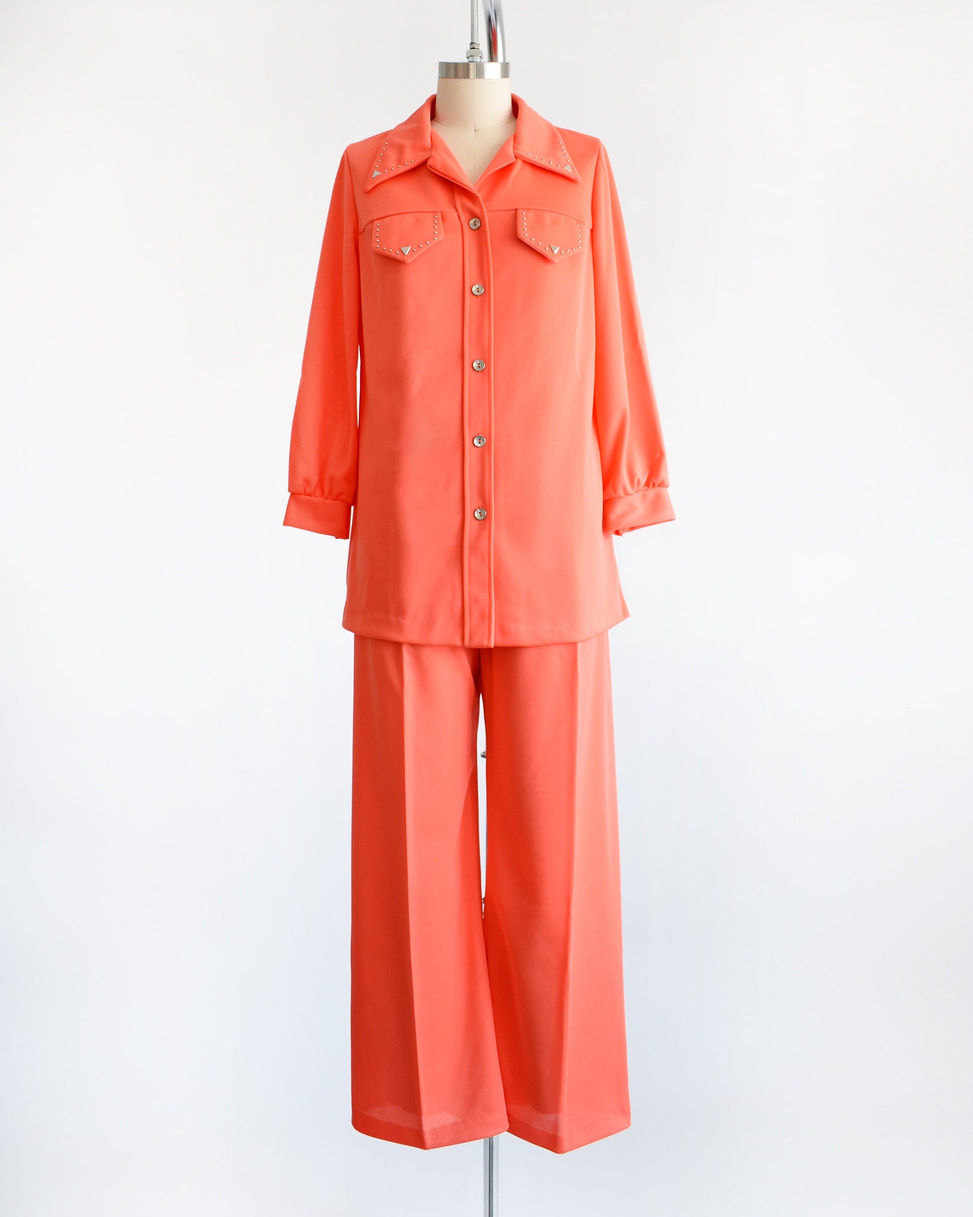 vintage 70s orange matching blouse with silver studs with wide leg pants on a dress form