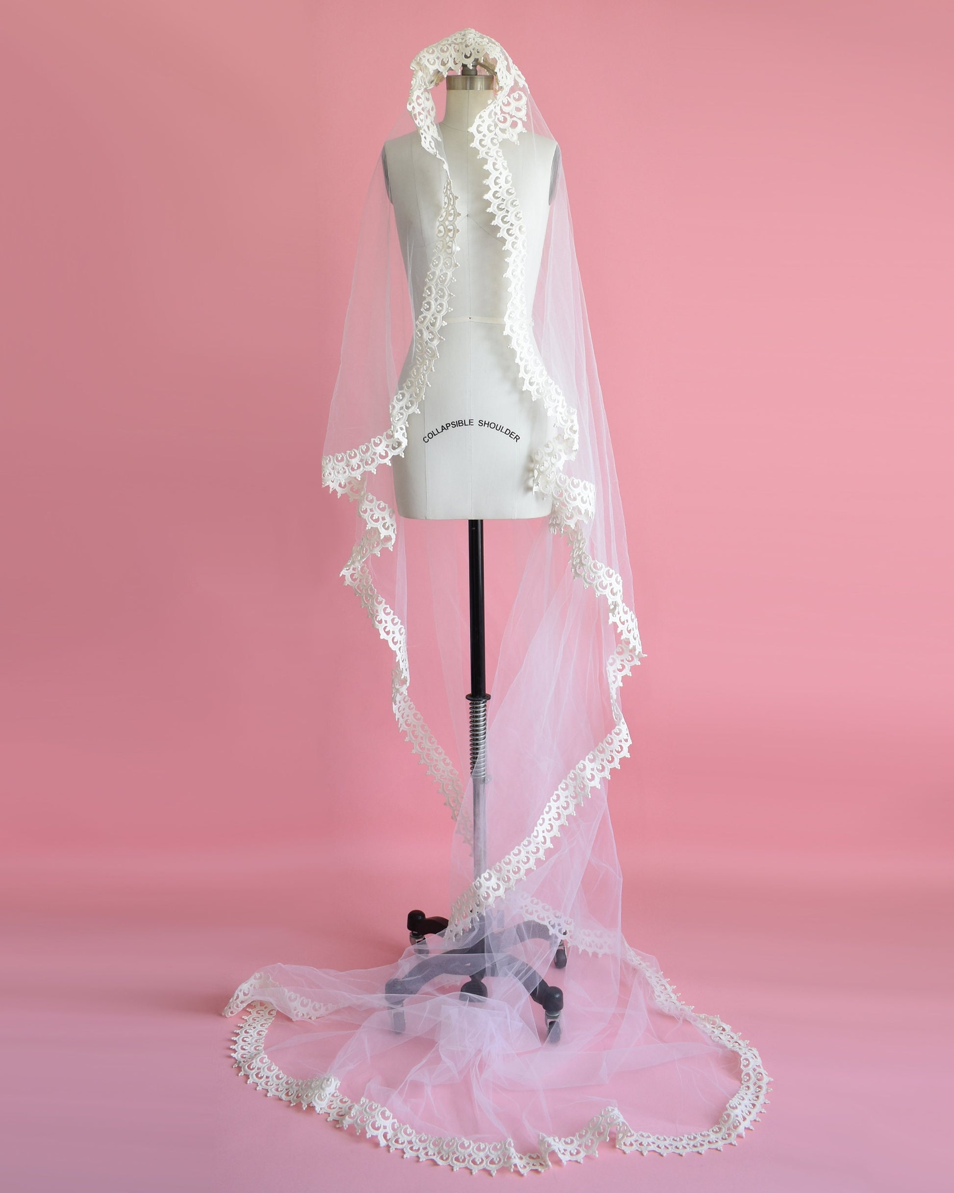 photo of the long wedding veil with matching lace trim on a dress form