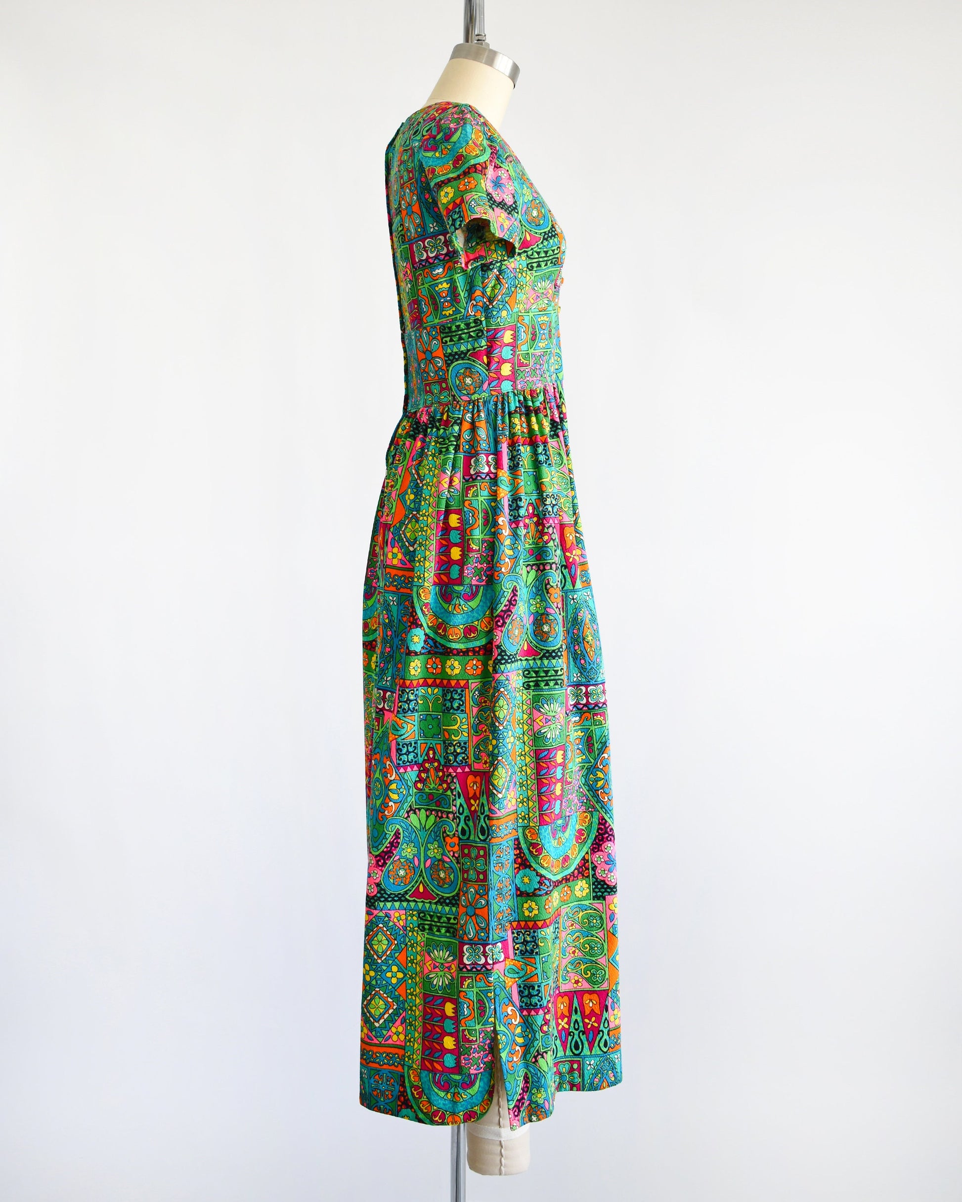 side view of a vintage 60s multicolored and multi-print floral maxi dress on a dress form