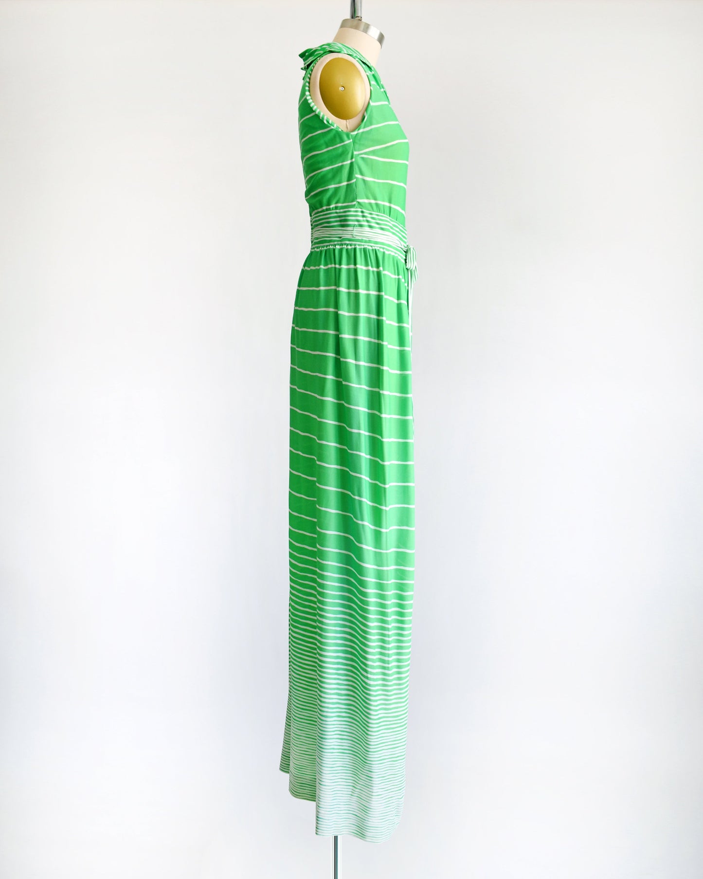 side view of a vintage green and white striped maxi dress on a dress form