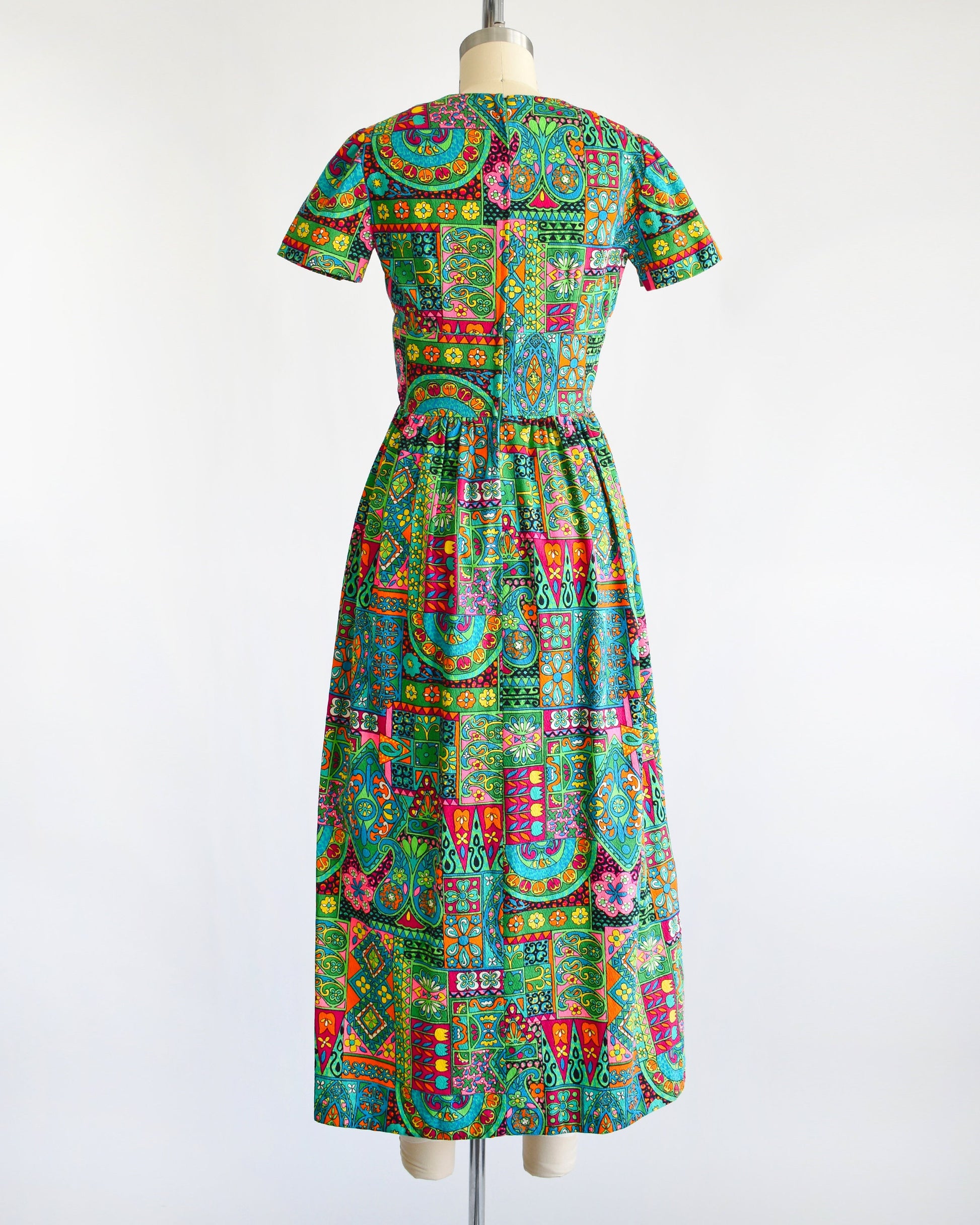 back view of a vintage 60s multicolored and multi-print floral maxi dress on a dress form