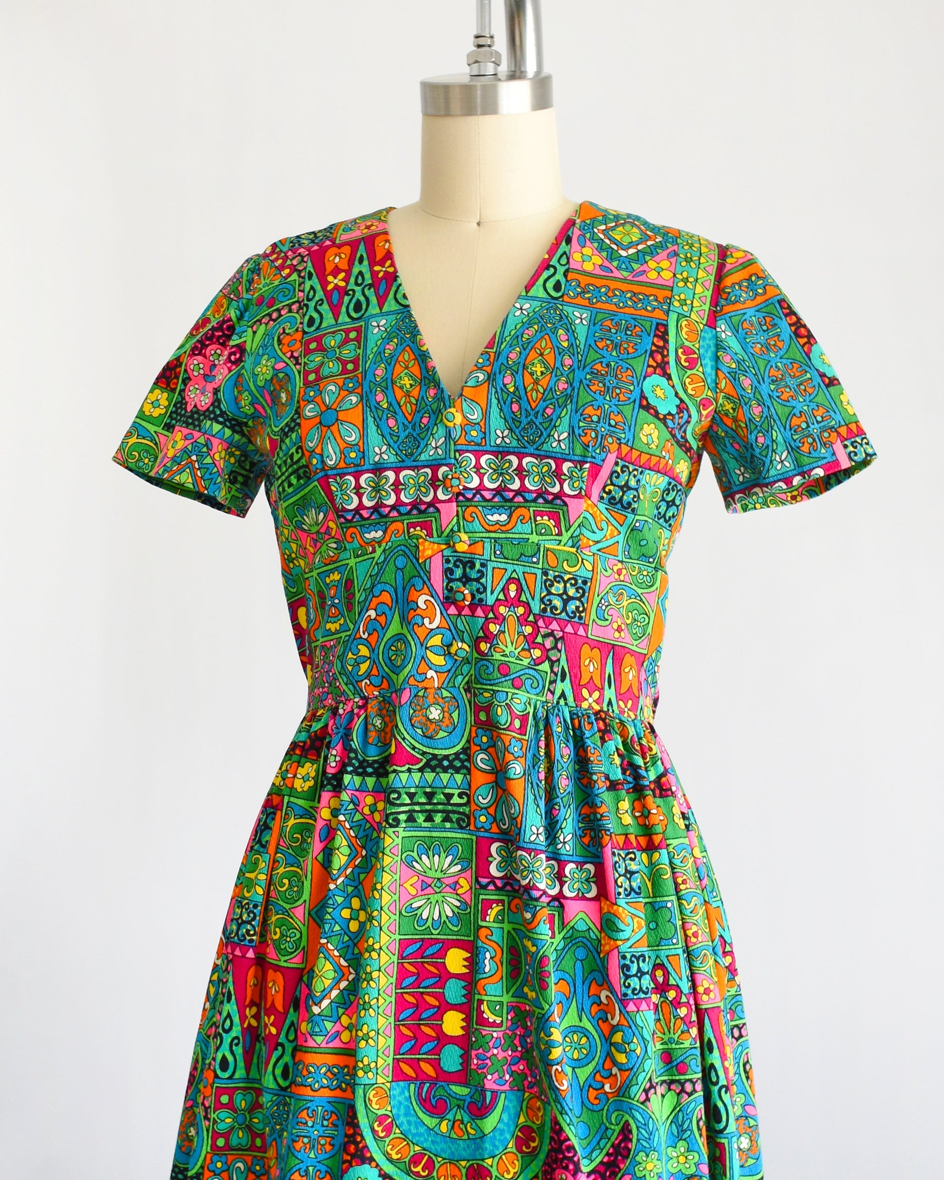 side front view of a vintage 60s multicolored and multi-print floral maxi dress on a dress form