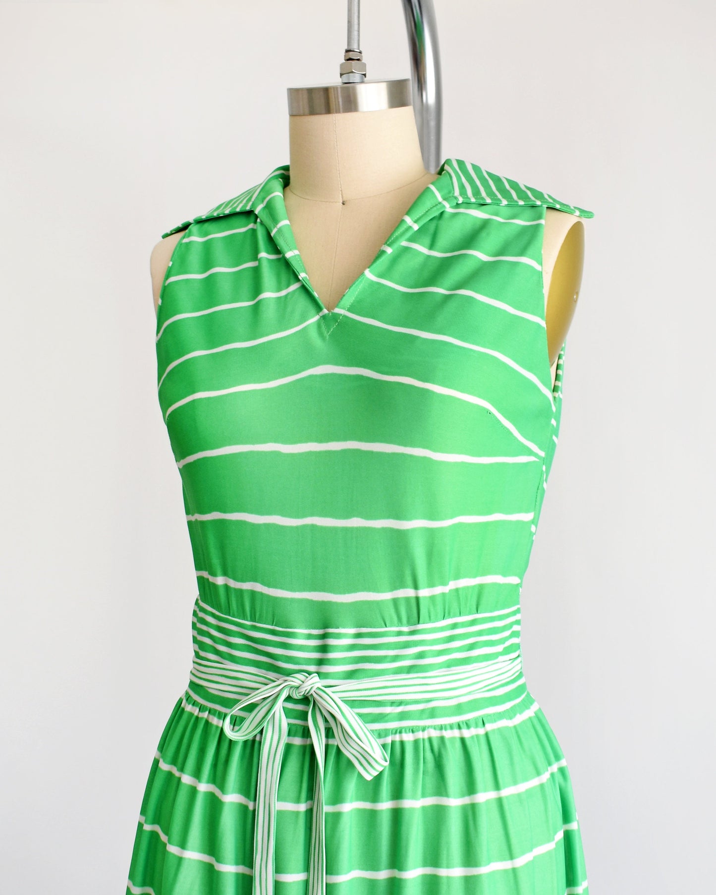 front side view of a vintage green and white striped maxi dress on a dress form
