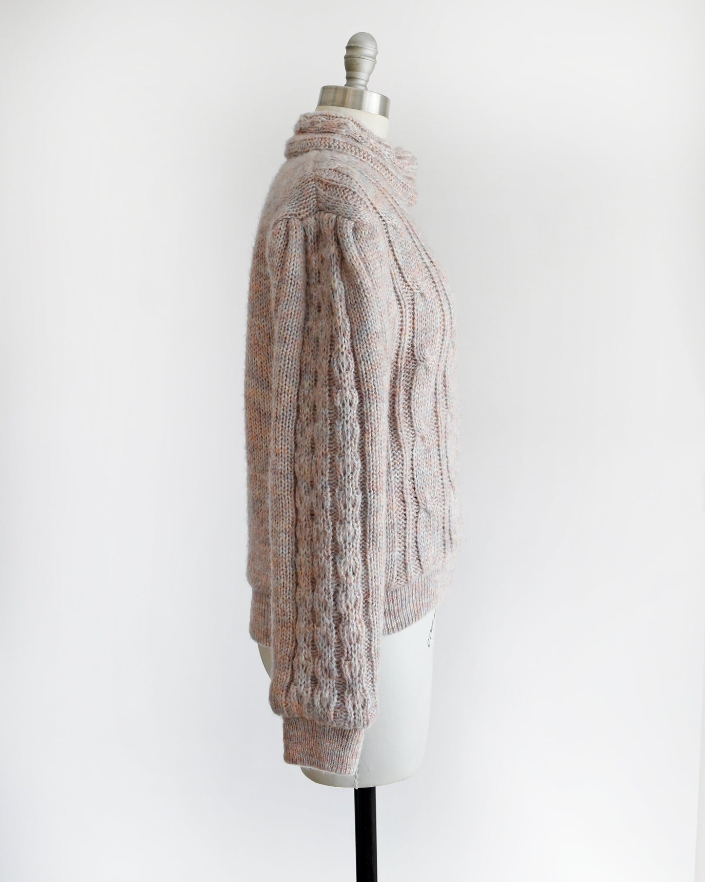 Side view of a vintage 80s light purple cable knit sweater coat on a dress form.