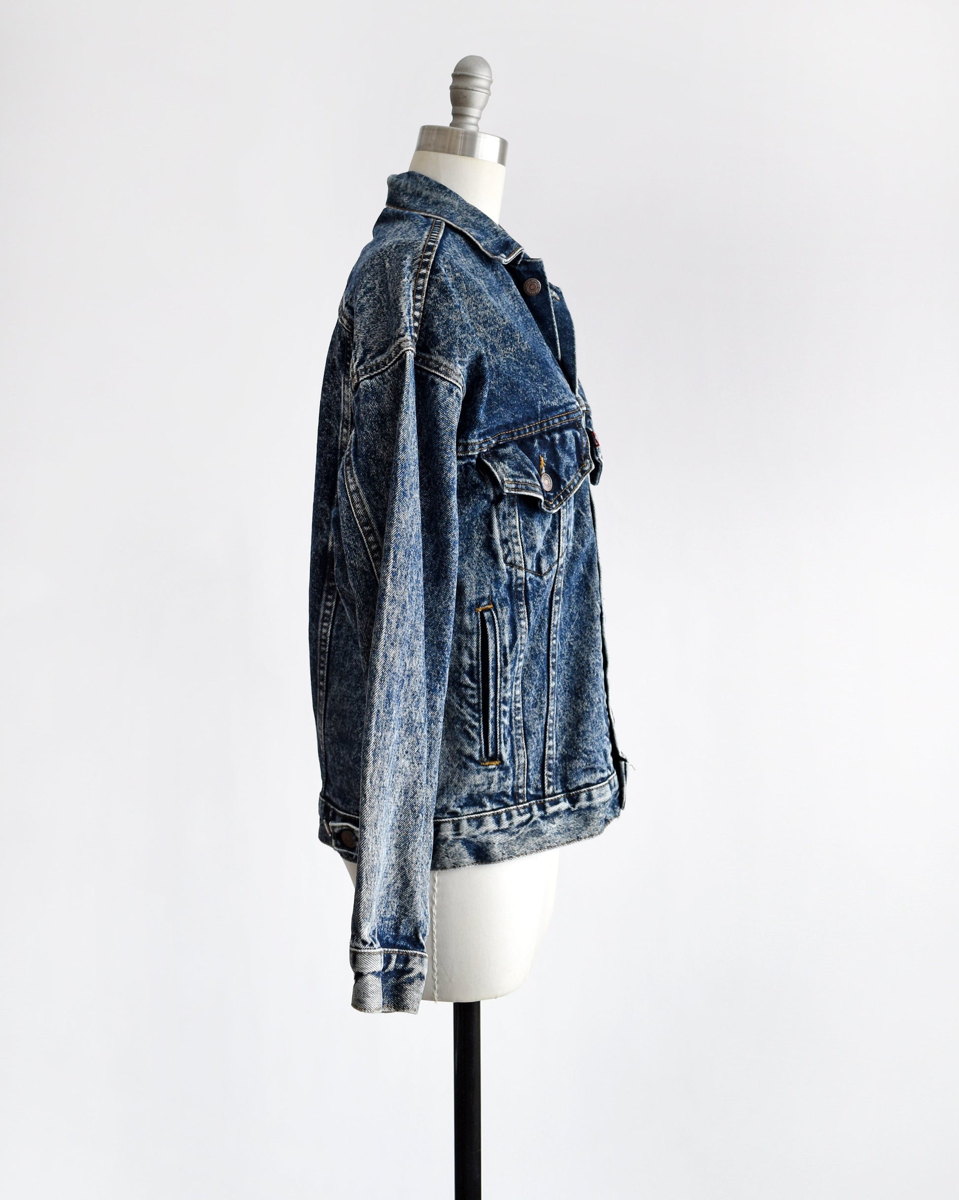 Side view of a vintage 80s Levis blue jean denim jacket button up on a dress form.