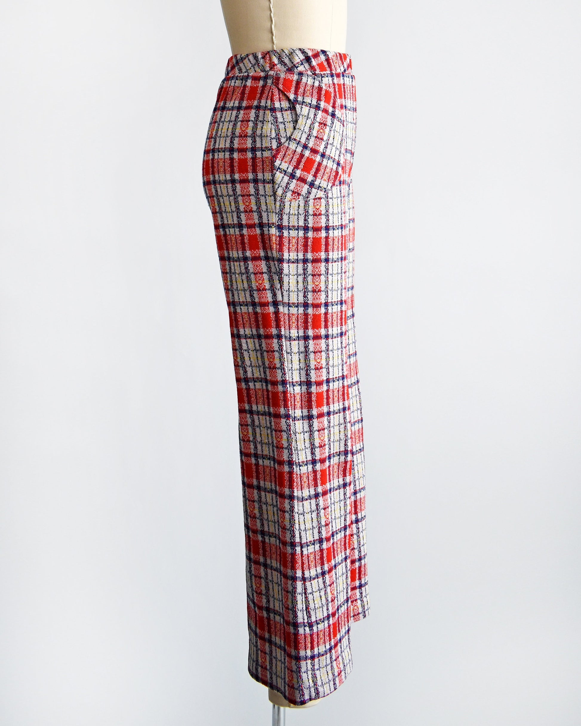 Side view of a vintage pair of 70s red white and blue plaid wide leg pants on a dress form.