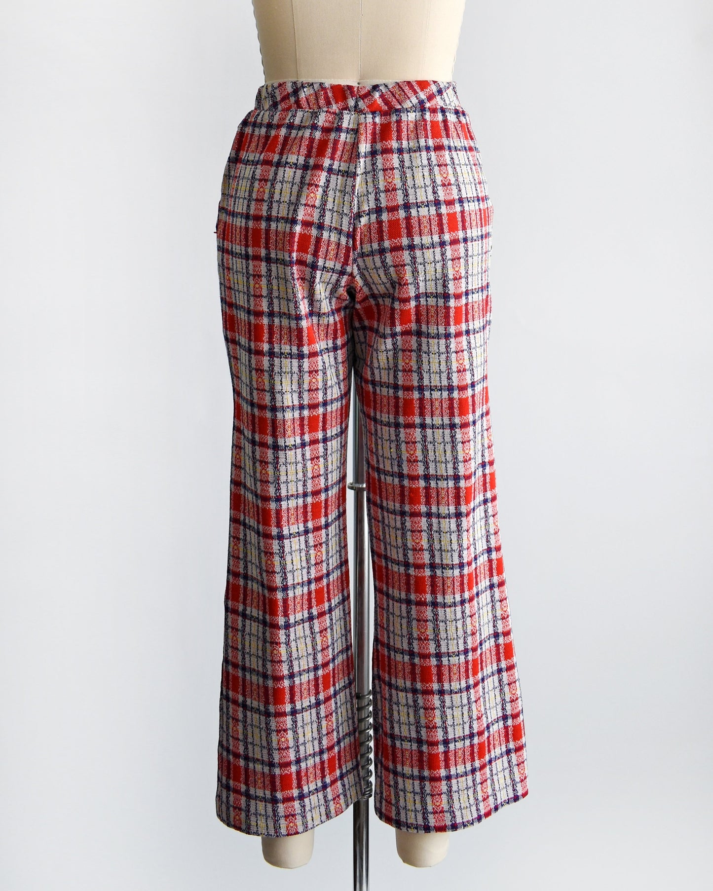 Back view of a vintage pair of 70s red white and blue plaid wide leg pants on a dress form.
