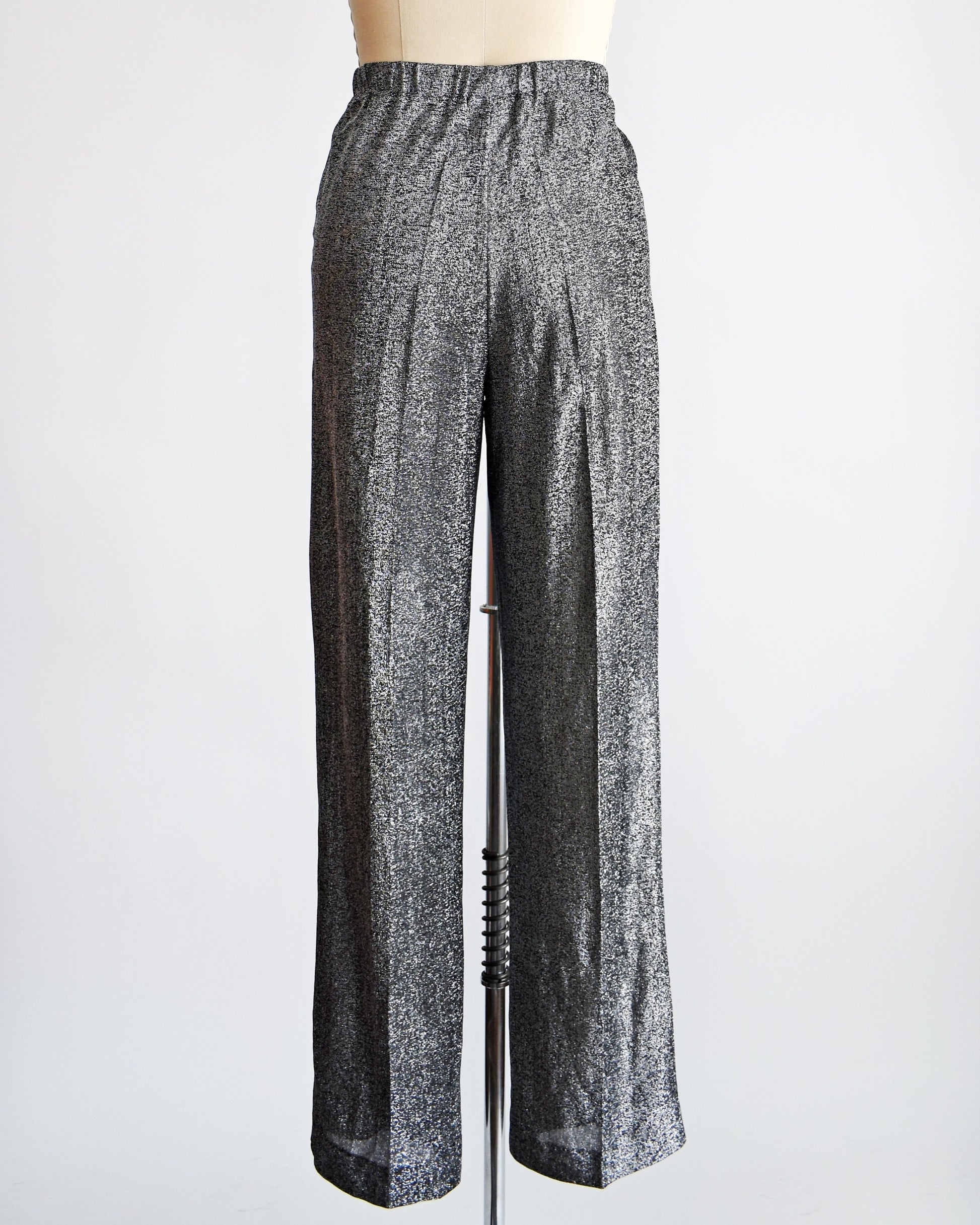 Back view of a vintage pair of 70s silver and black metallic pants on a dress form.