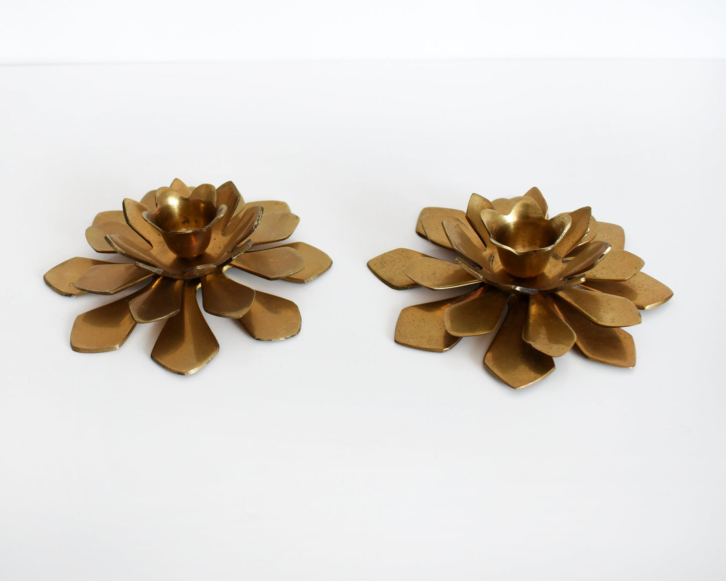 overhead shot of a pair of vintage brass lotus candle holders