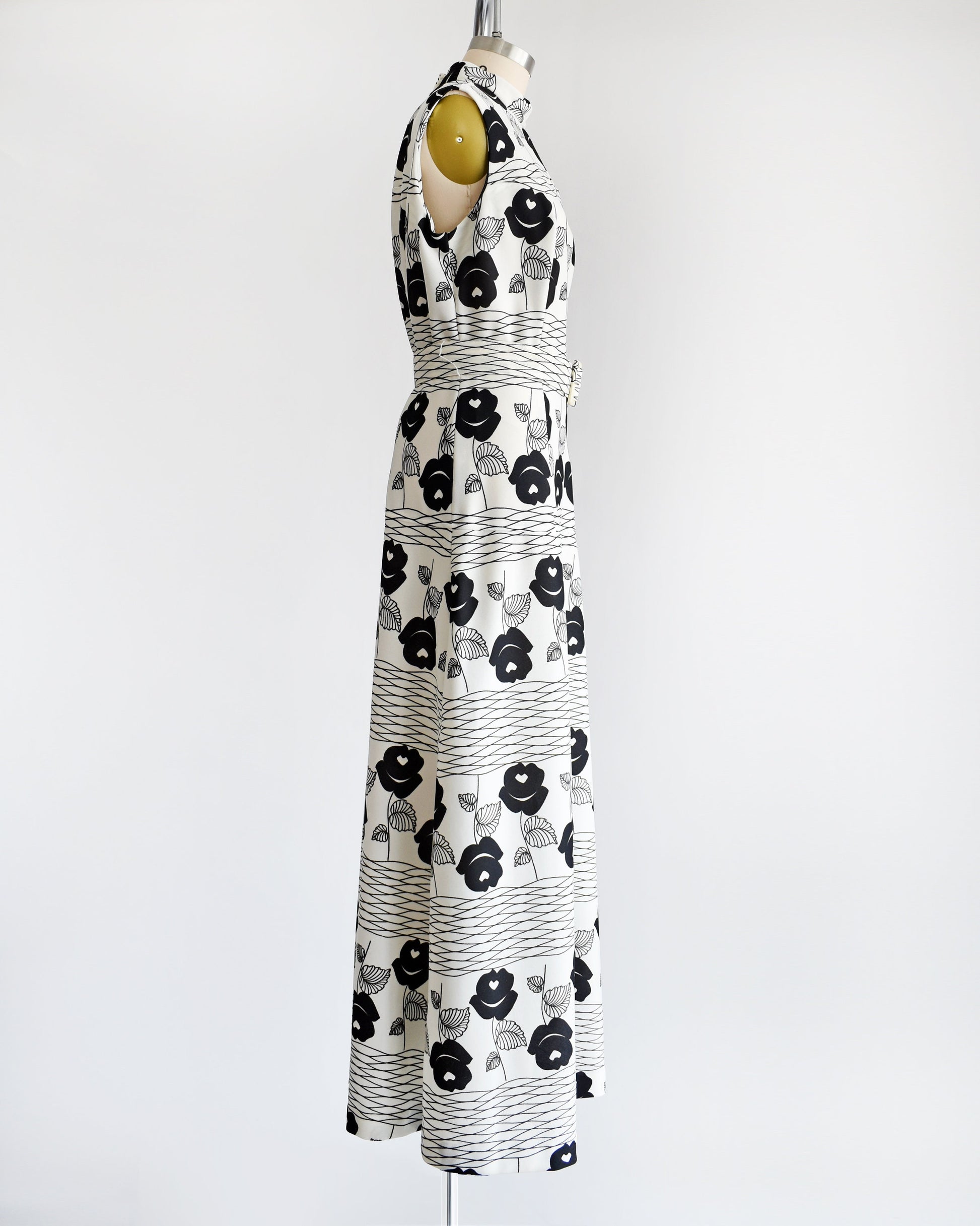 Side view of a vintage 70s white maxi dress black floral print with wavy horizontal lines and matching belt.