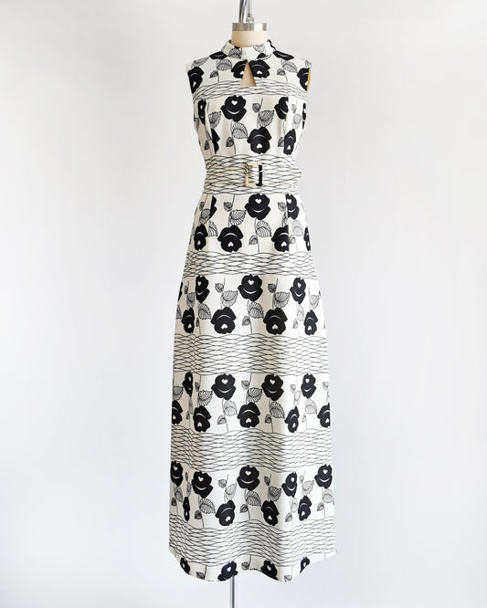 A vintage 70s white maxi dress black floral print with wavy horizontal lines and matching belt.
