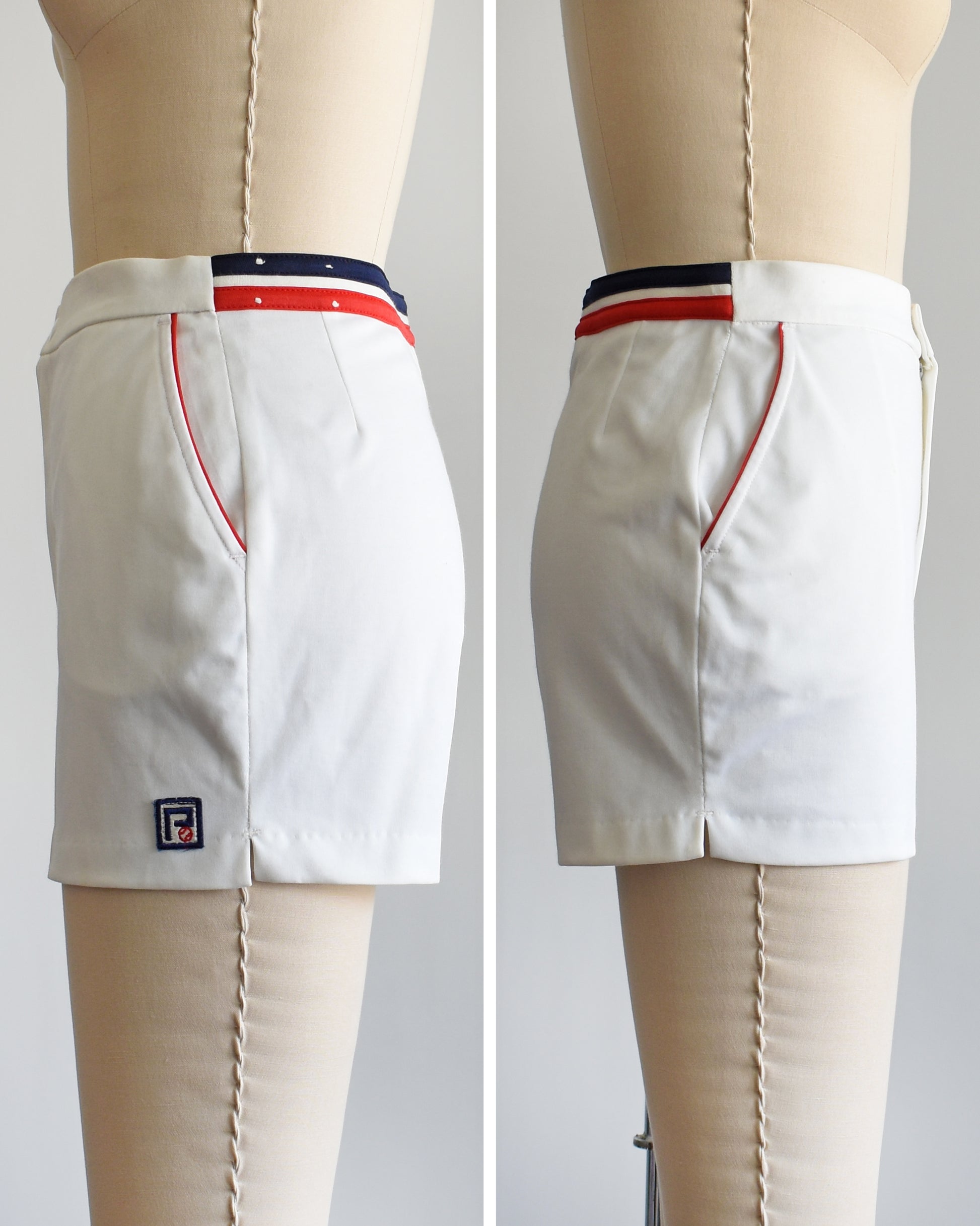 side by side views of a vintage 1970s white tennis shorts on a dress form. The shorts have red and blue bands along the waist on the back and red trim around the pockets