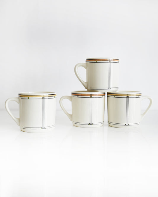 Set of four vintage Frank Lloyd Wright Martin House white mugs with gold trim on a white background