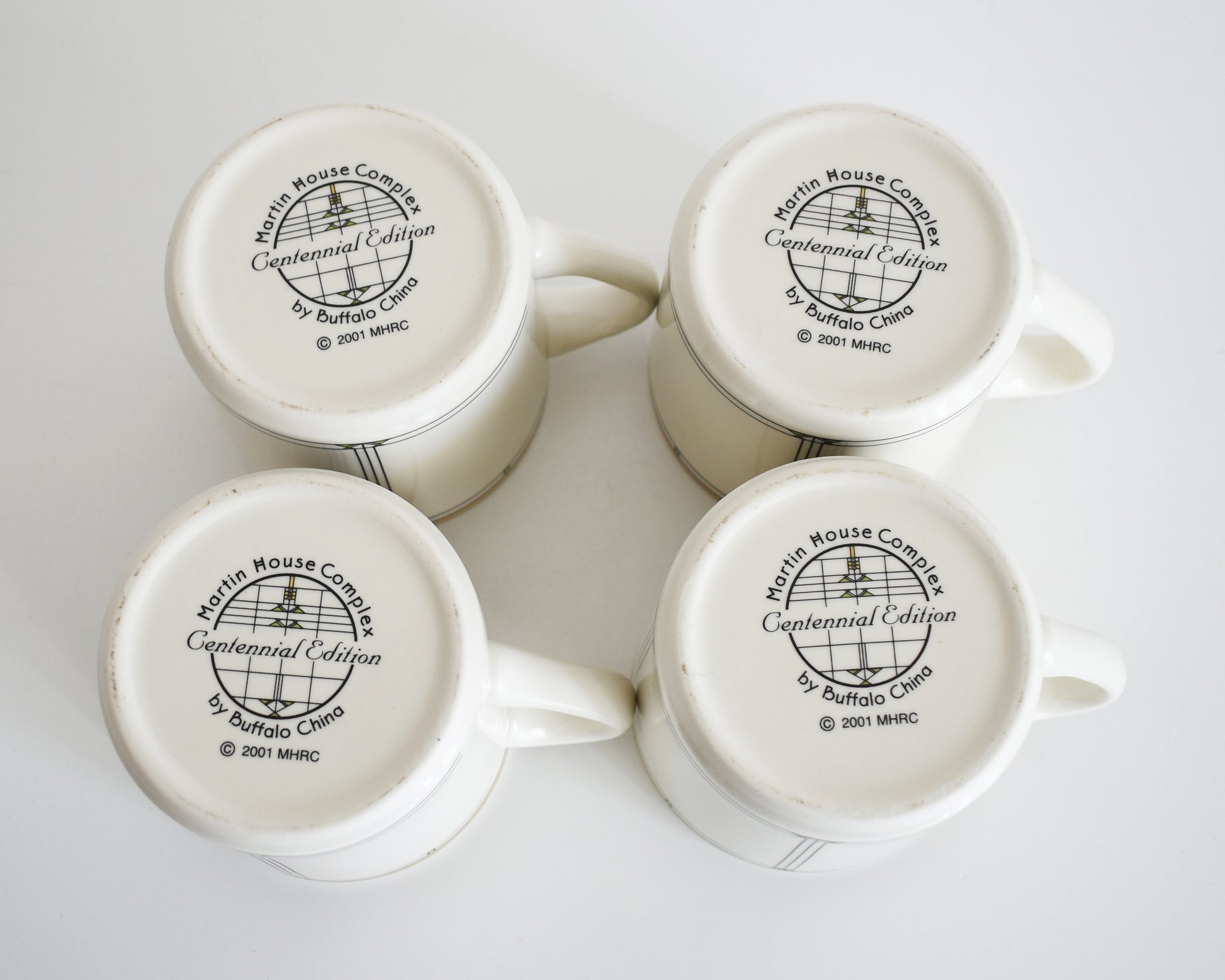 overhead shot of the base of the mugs that says Martin House Complex, Centennial Edition, by Buffalo China, 2001