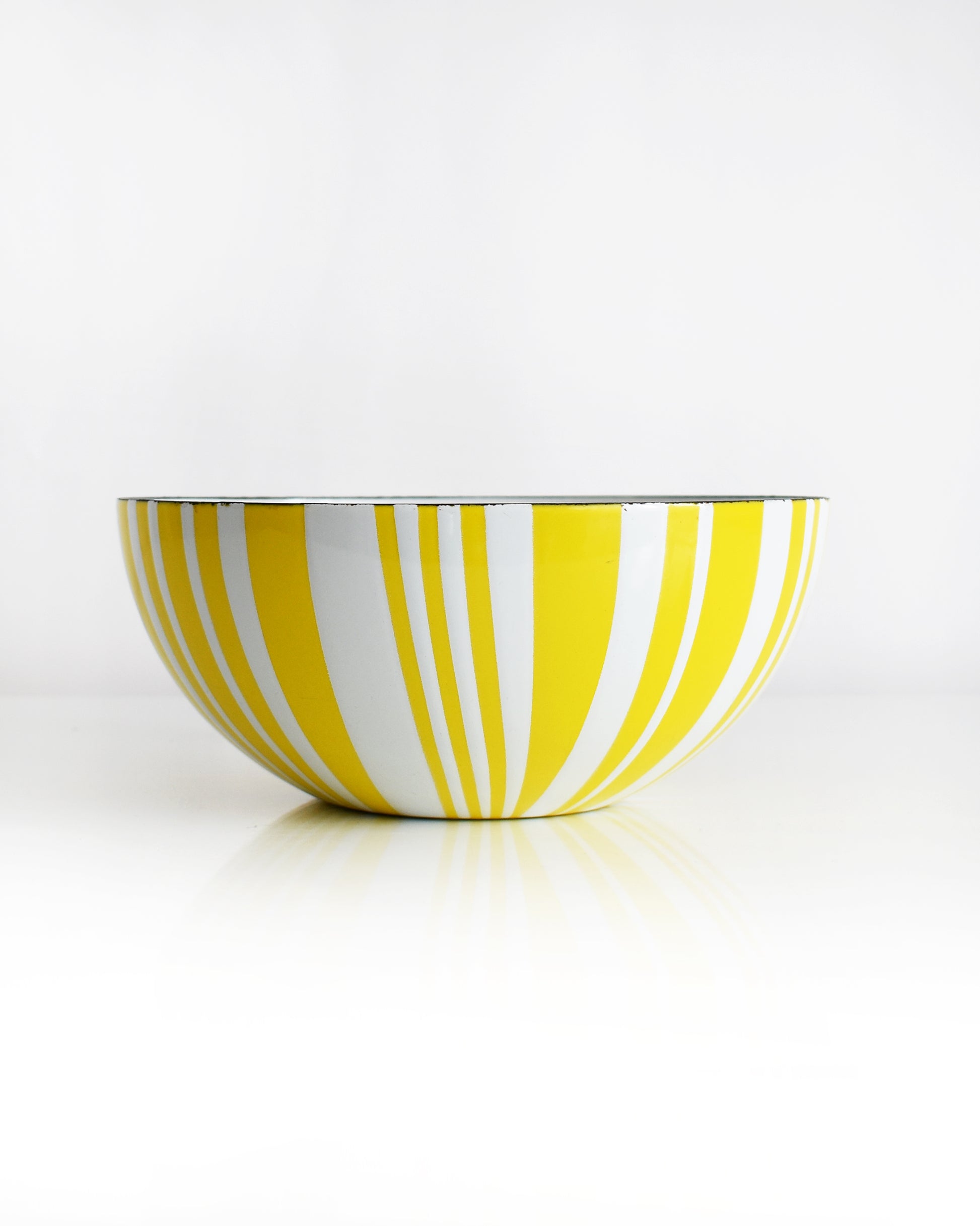 a vintage yellow and white striped Cathrineholm bowl on a white background