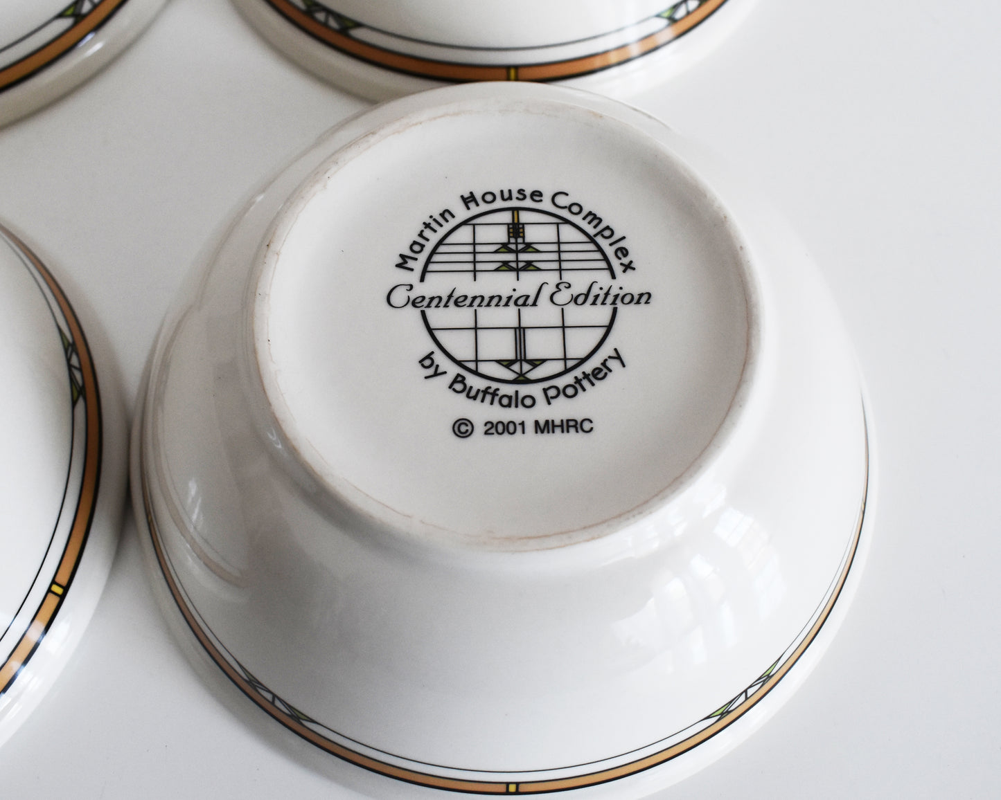 overhead shot of the base of the mugs that says Martin House Complex, Centennial Edition, by Buffalo China, 2001