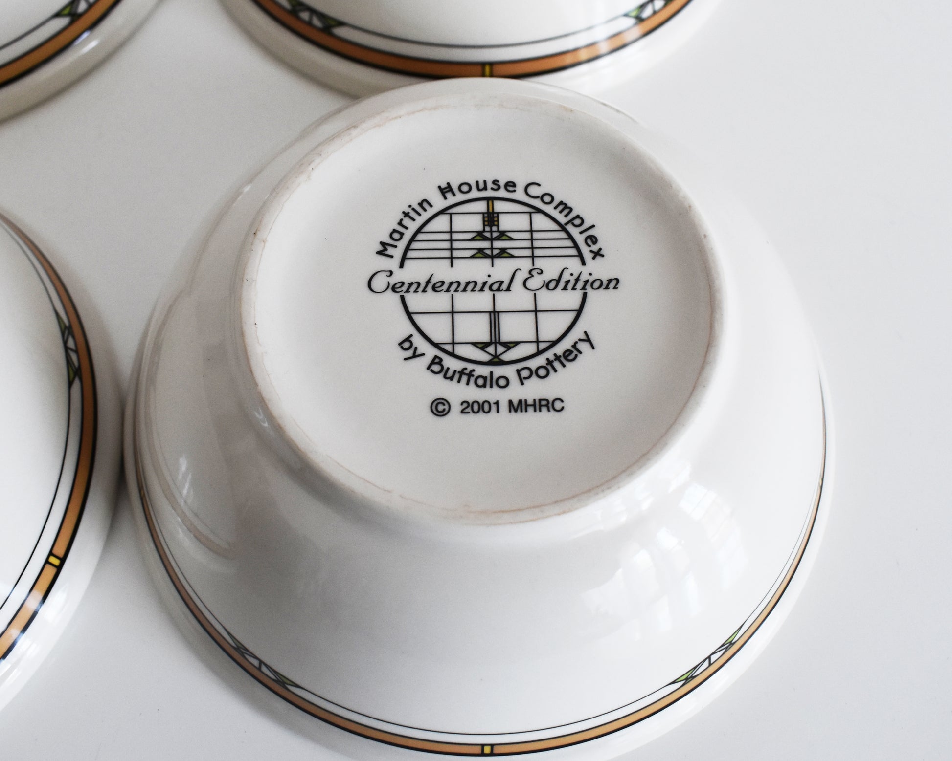 overhead shot of the base of the mugs that says Martin House Complex, Centennial Edition, by Buffalo China, 2001
