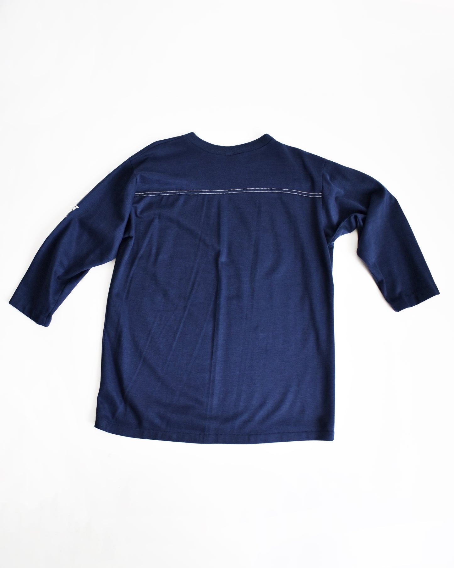 Navy blue shirt with white stitching on a white background