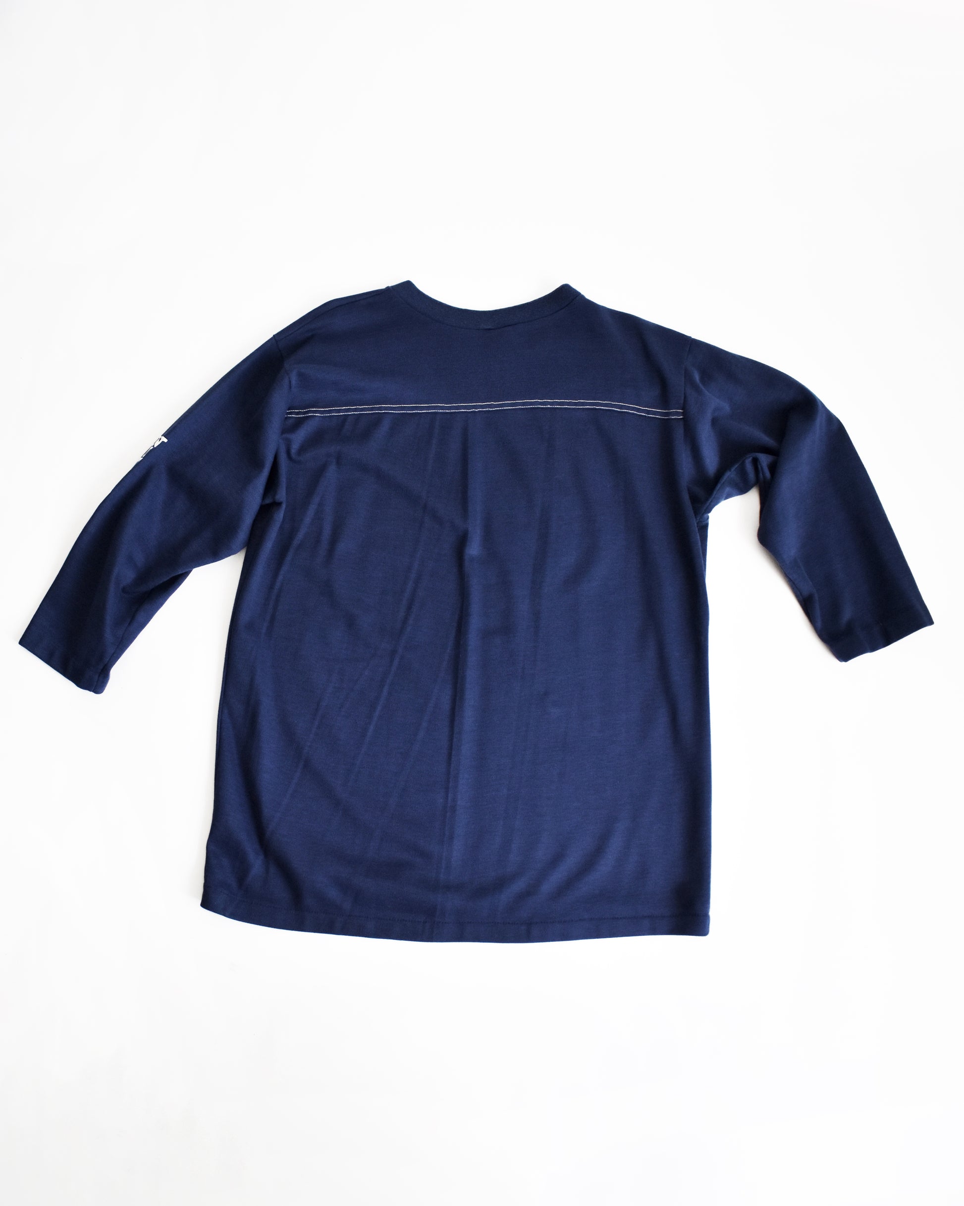 Navy blue shirt with white stitching on a white background