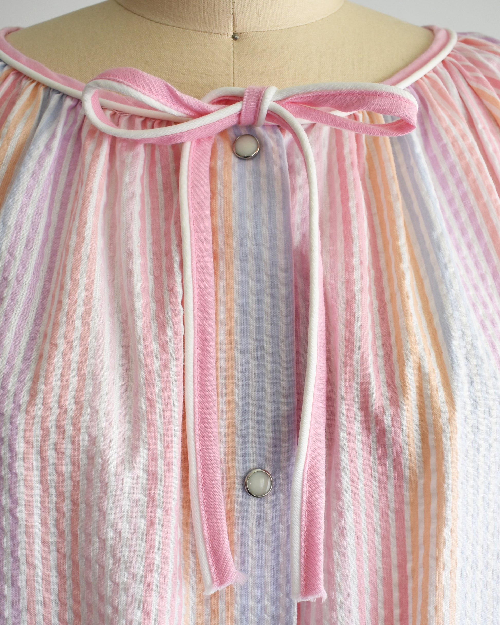 close up of the pink and white ribbon at the collar