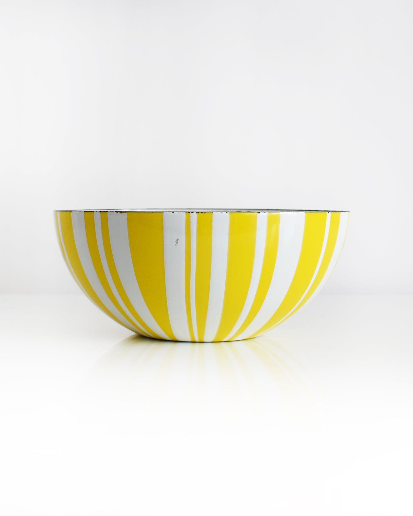 a vintage yellow and white striped Cathrineholm bowl on a white background