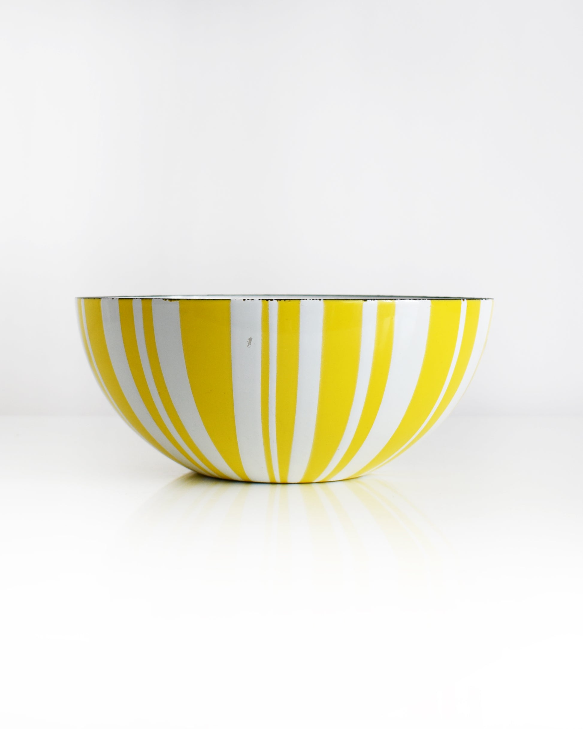 a vintage yellow and white striped Cathrineholm bowl on a white background