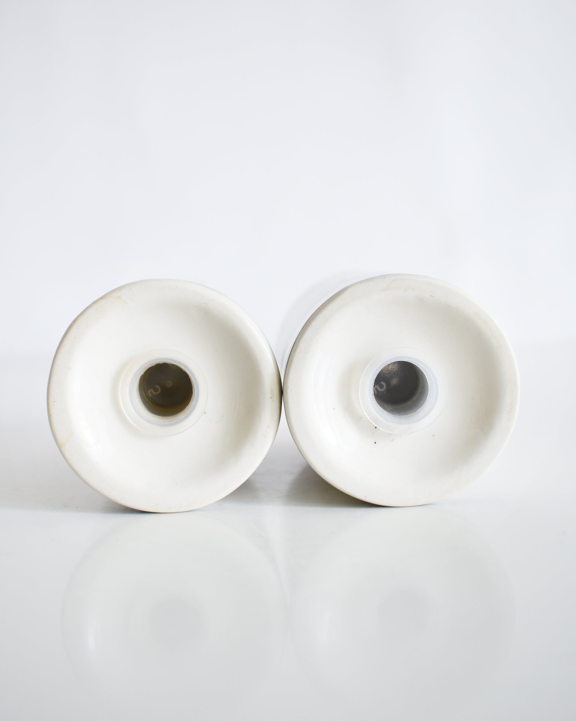 the underside of a set of ceramic Frank Lloyd Wright Martin House salt and pepper shakers on a white background
