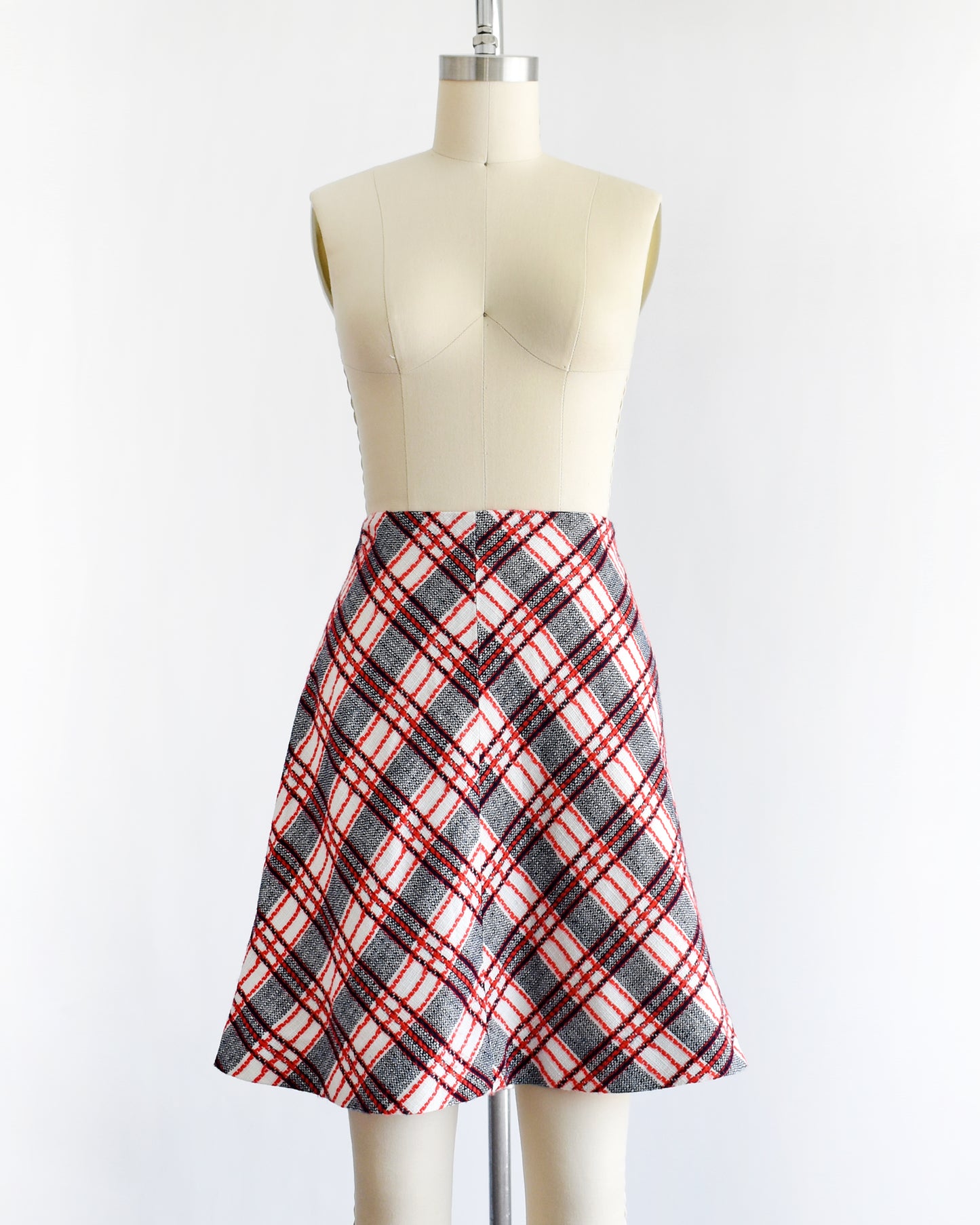 a vintage plaid skirt on a mannequin against a white background