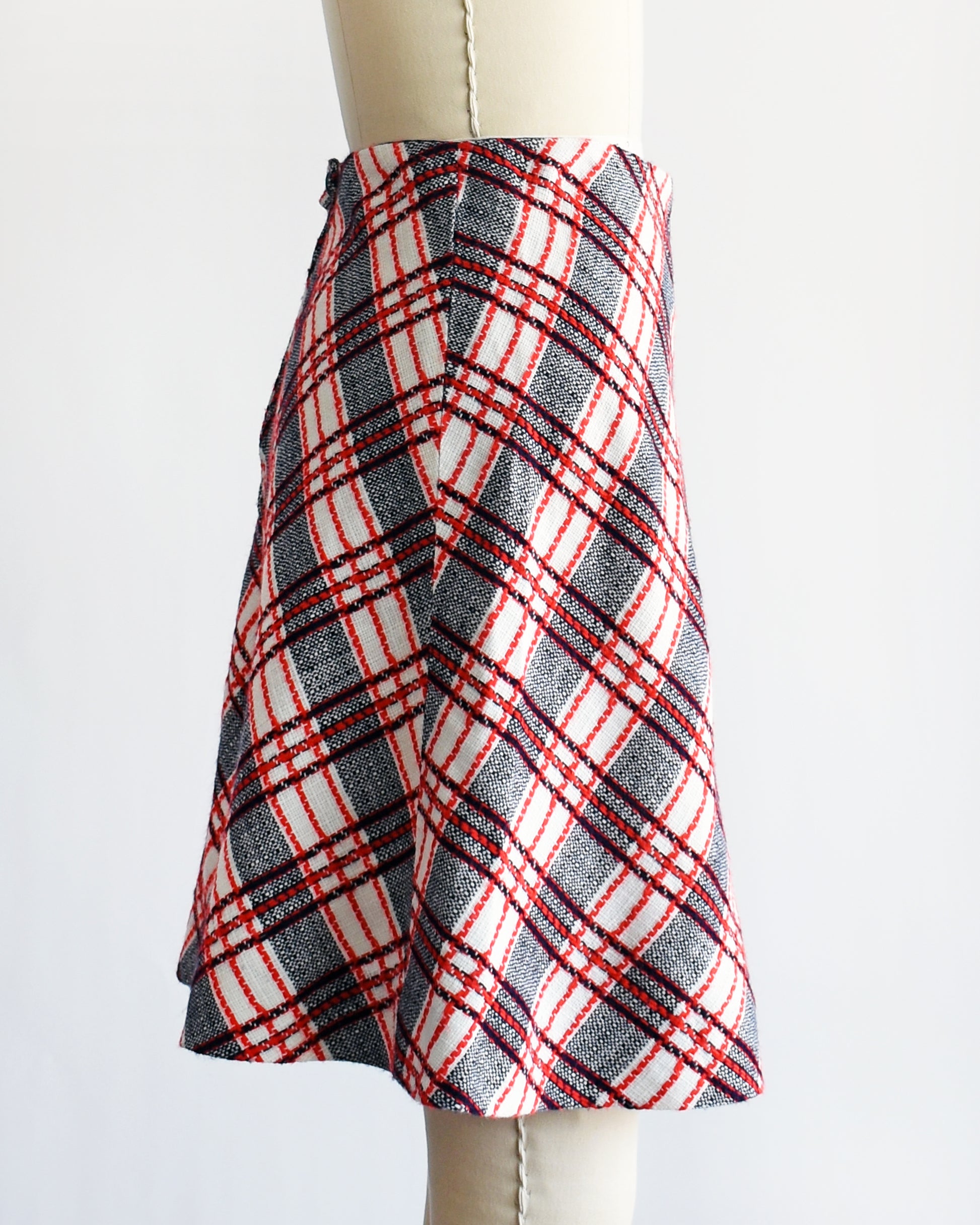 side view of a vintage plaid skirt on a mannequin against a white background