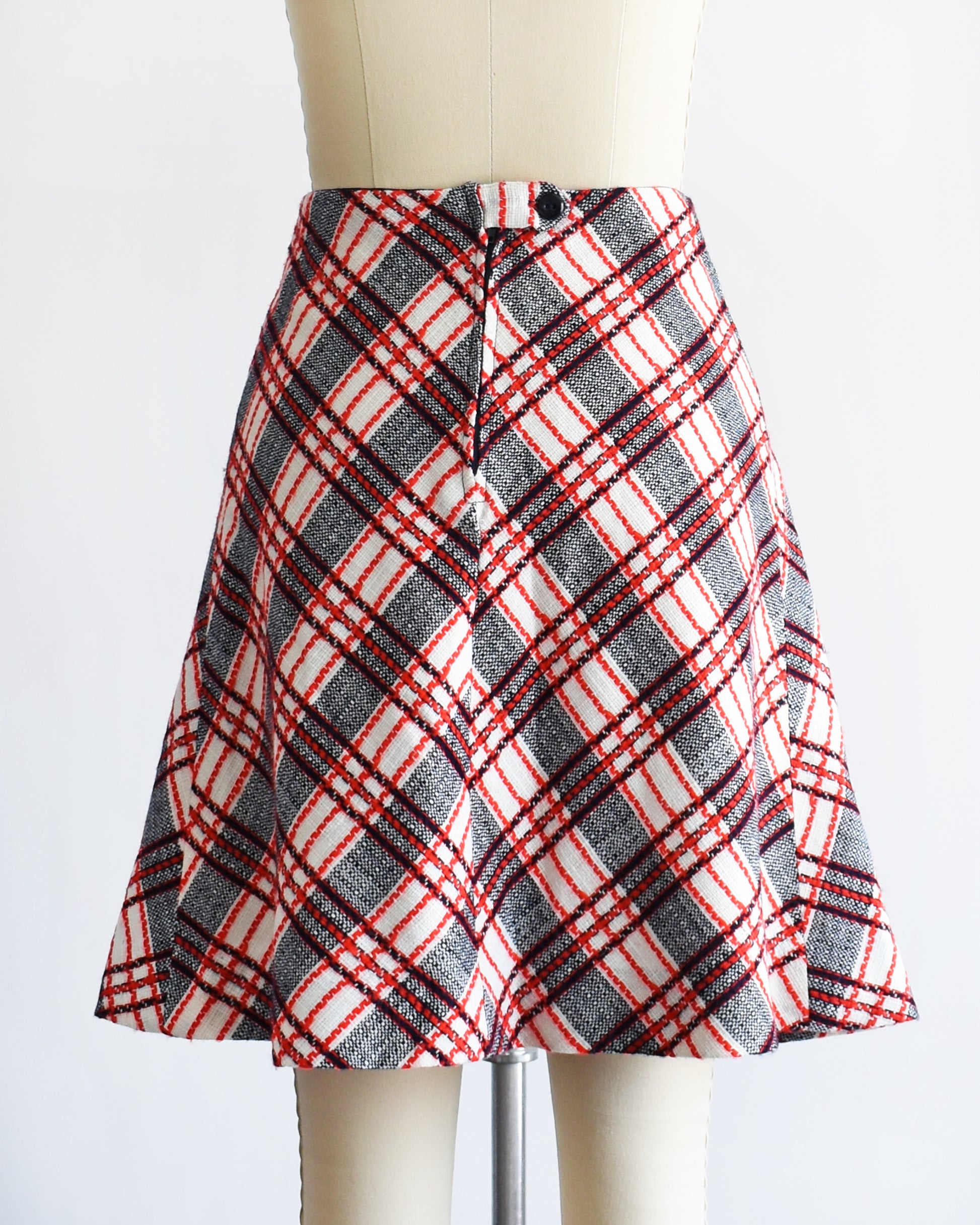 back button on a vintage plaid skirt on a mannequin against a white background