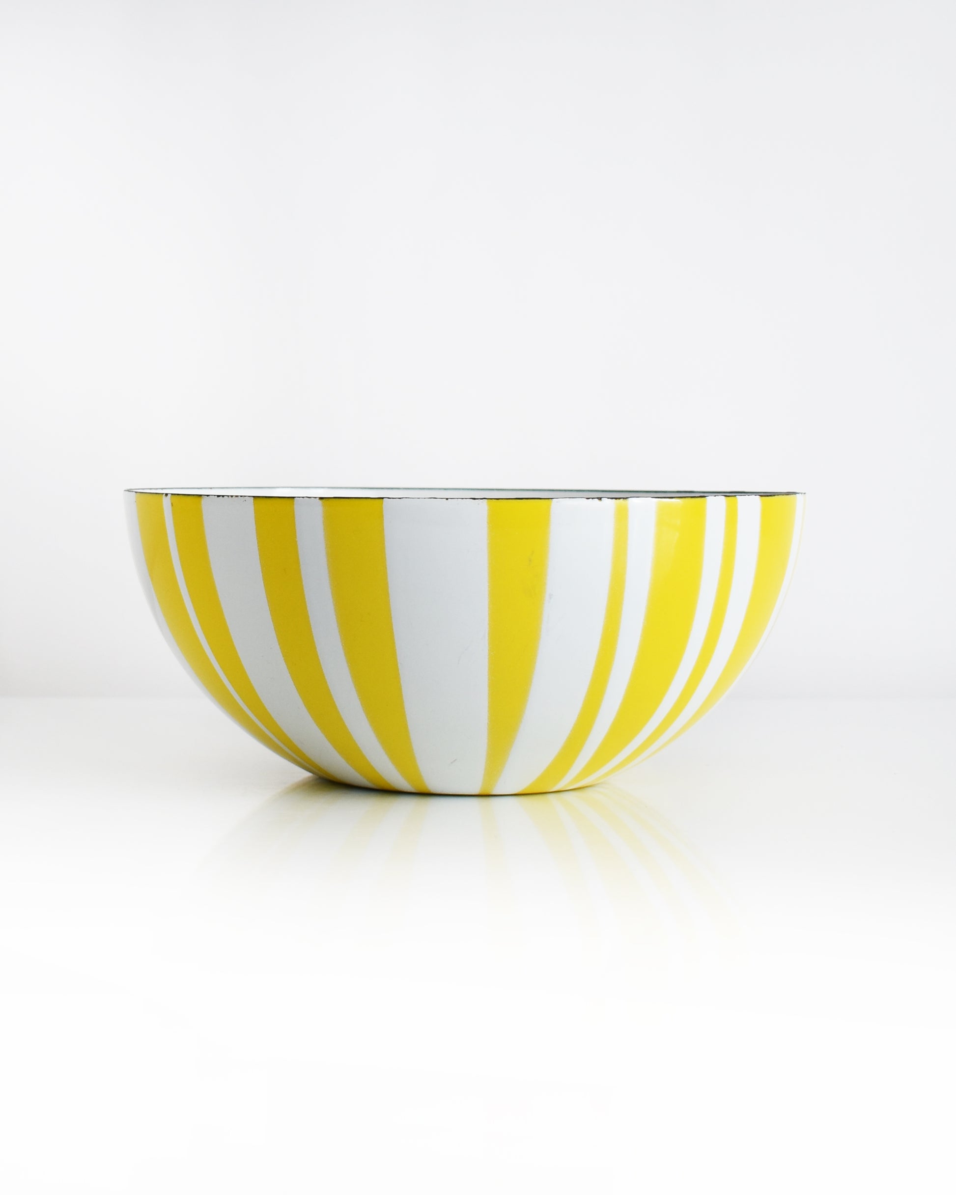 a vintage yellow and white striped Cathrineholm bowl on a white background