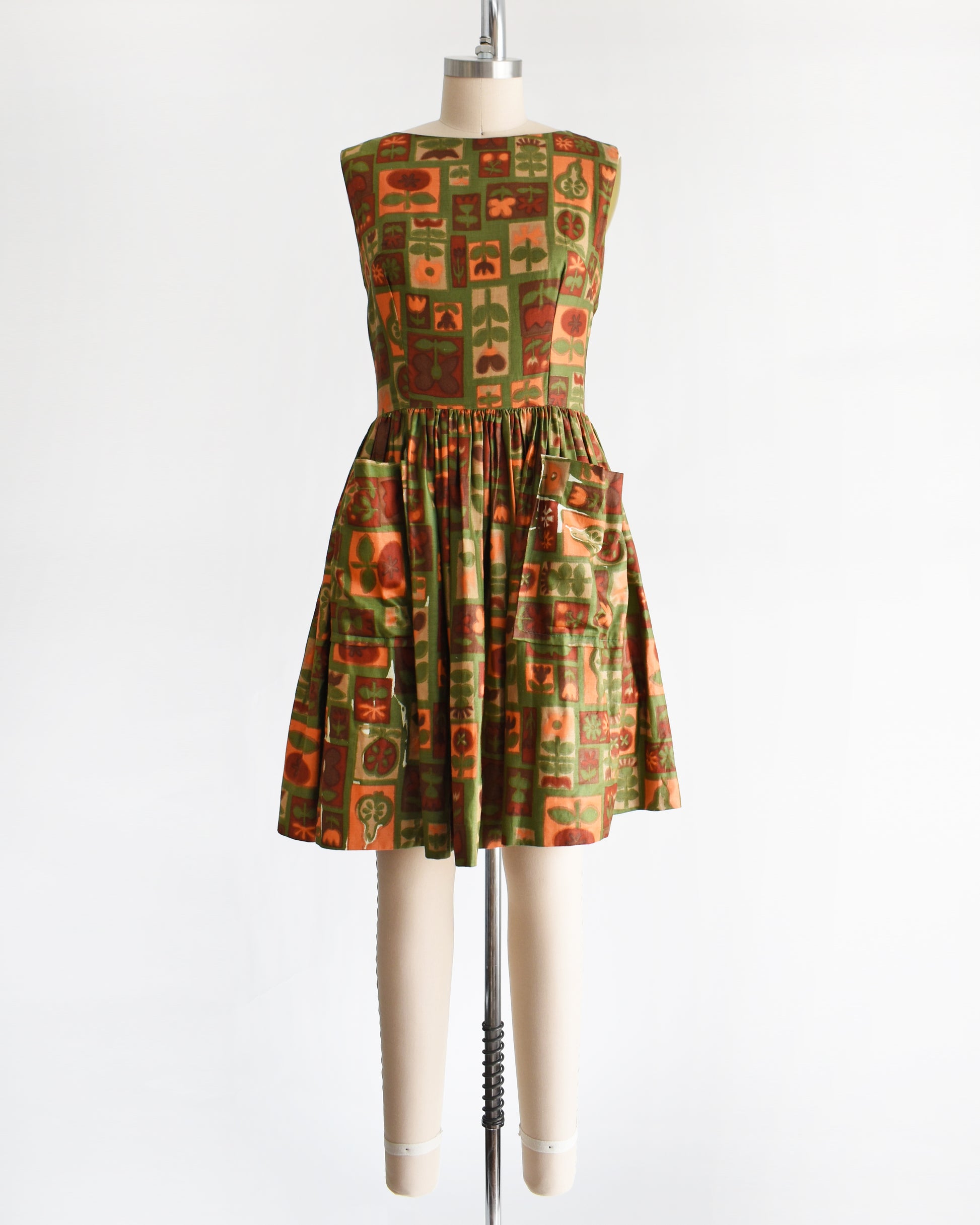 a vintage 1960s fruits and florals patterned dress on a mannequin against a white background
