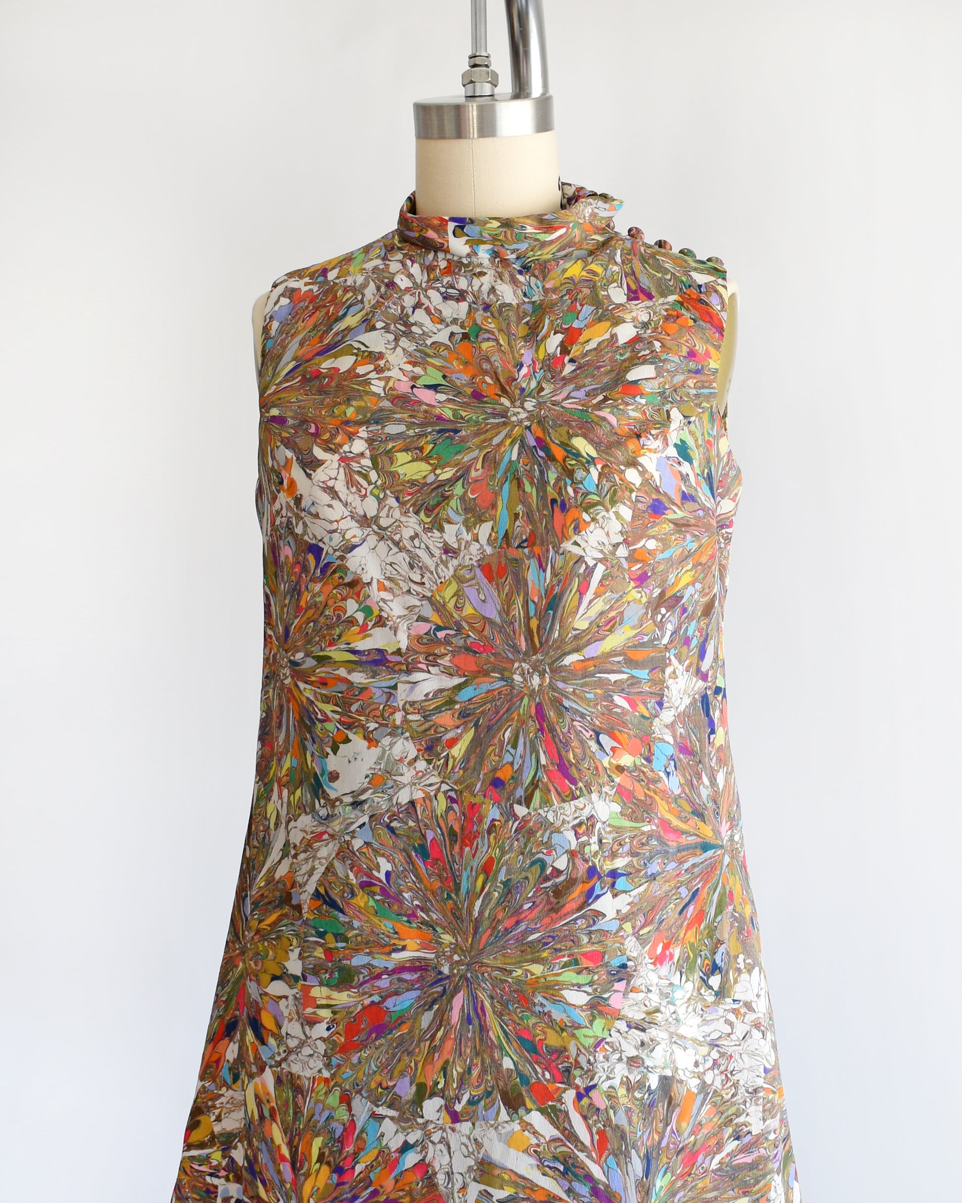 side front view of a vintage 1960s mod mini dress that has a multicolored psychedelic kaleidoscope print