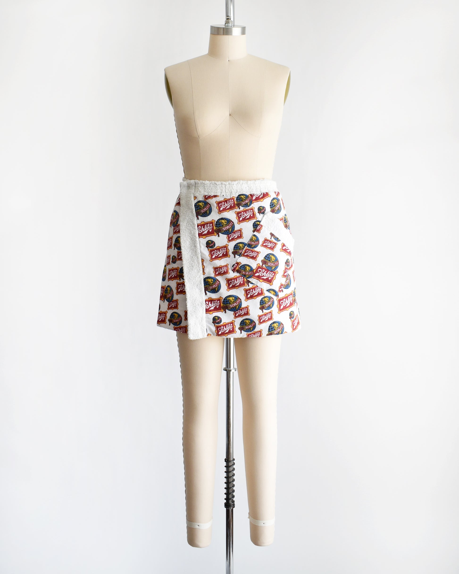 a vintage Schlitz terry cloth wrap towel skirt on a dress form against a white background
