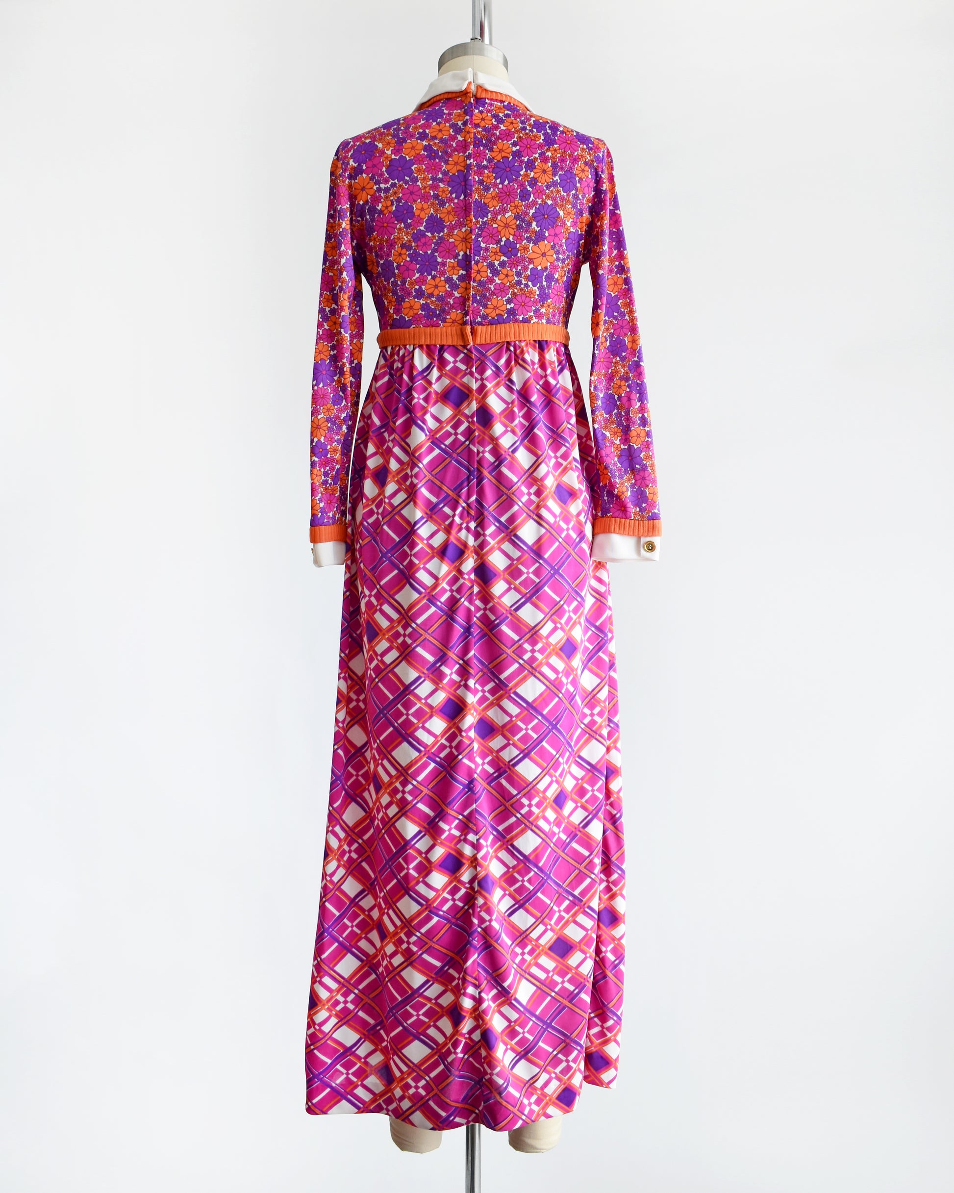 back view of a vintage 1960s/1970s colorful dress with a floral and geometric pattern on a mannequin against a white background