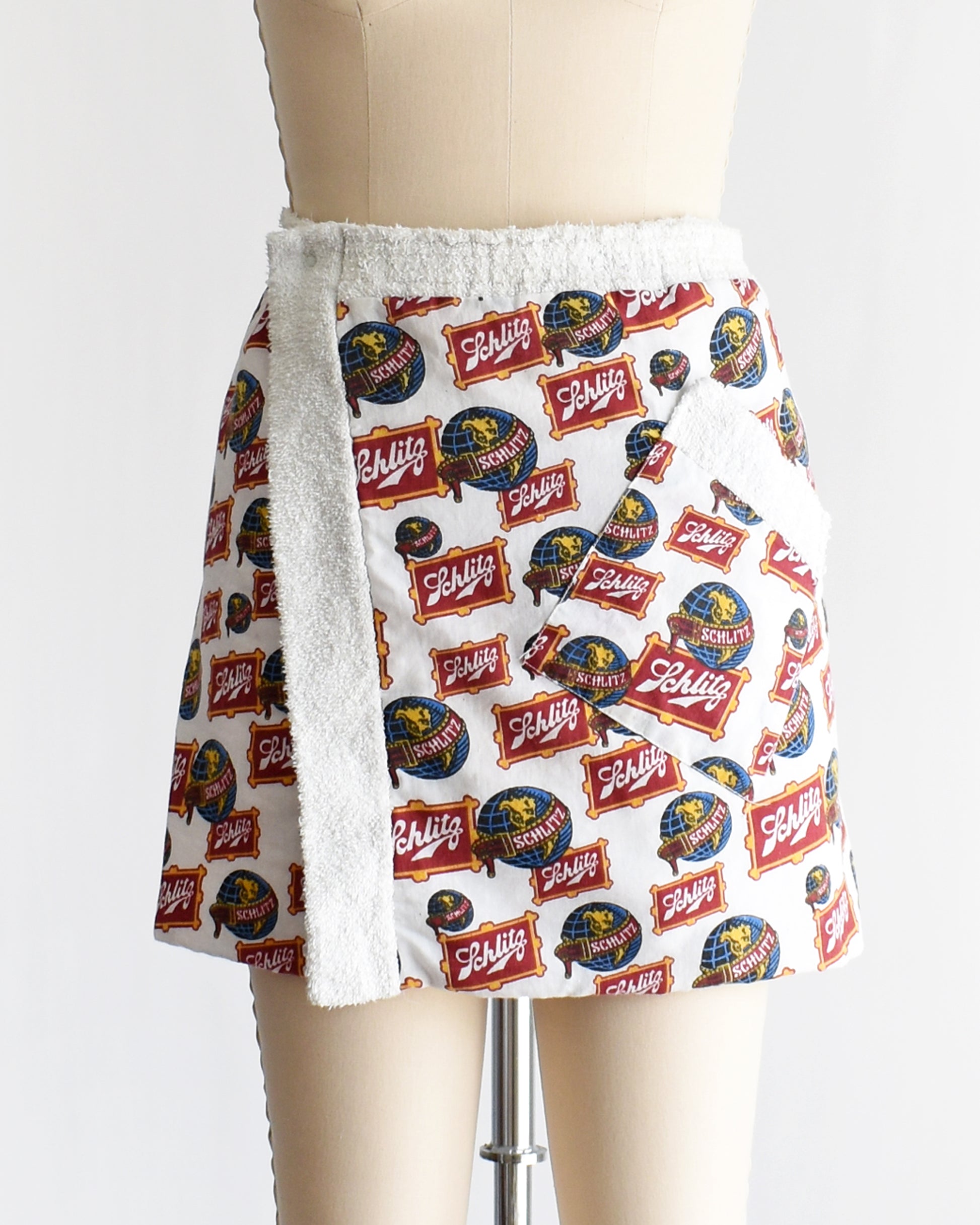 a vintage Schlitz terry cloth wrap towel skirt on a dress form against a white background