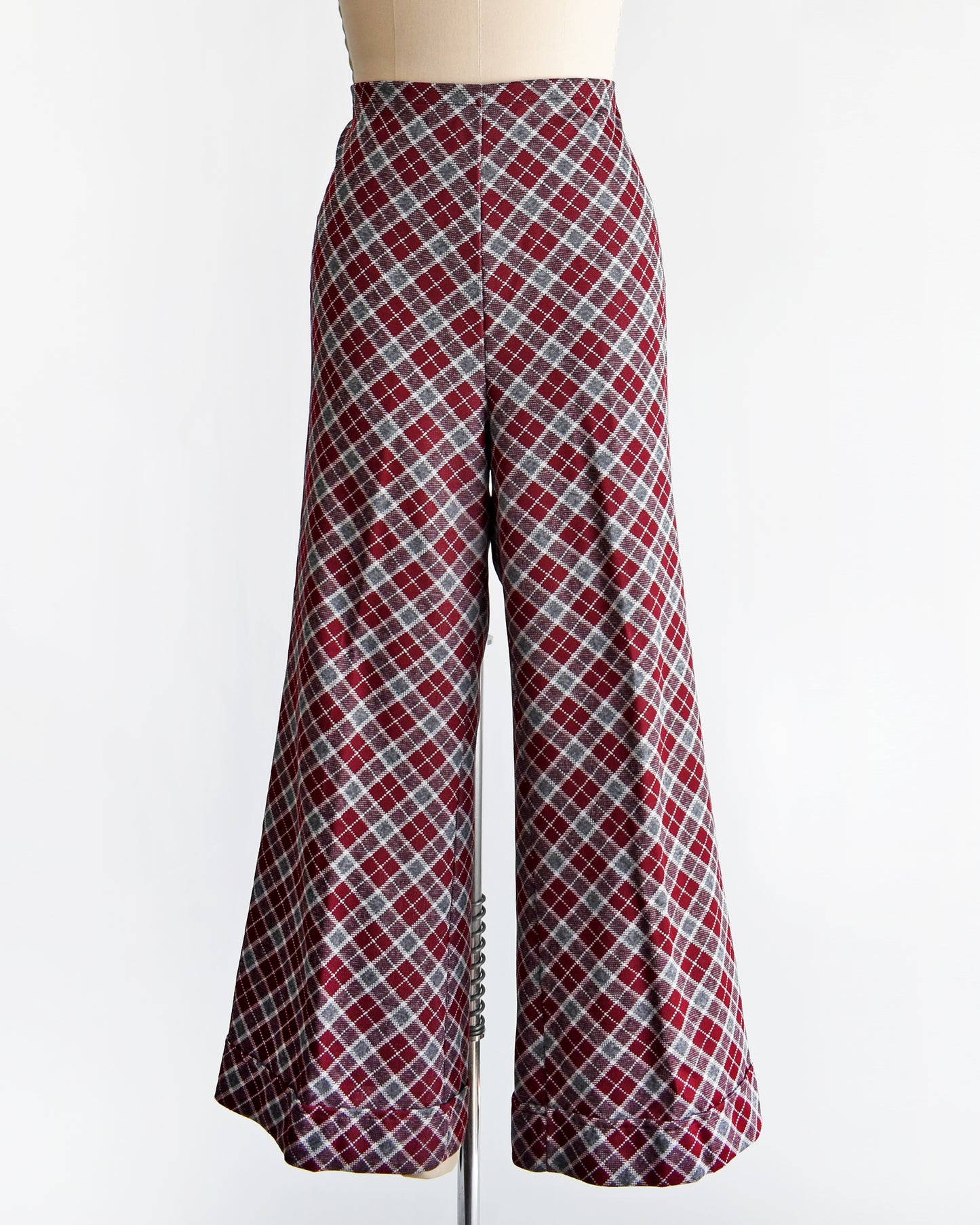 a vintage 1970s burgundy plaid bell bottom pants on a mannequin against a white background
