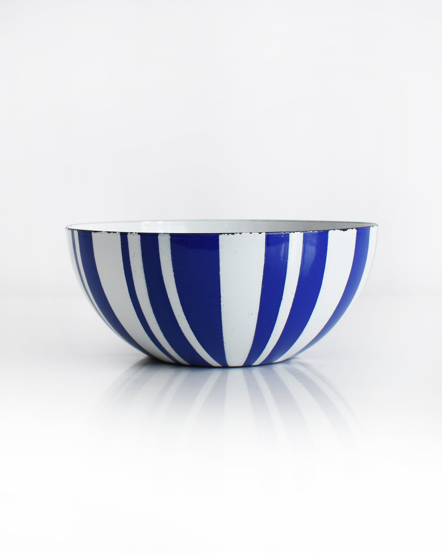 a vintage blue and white striped Cathrineholm bowl on a white background