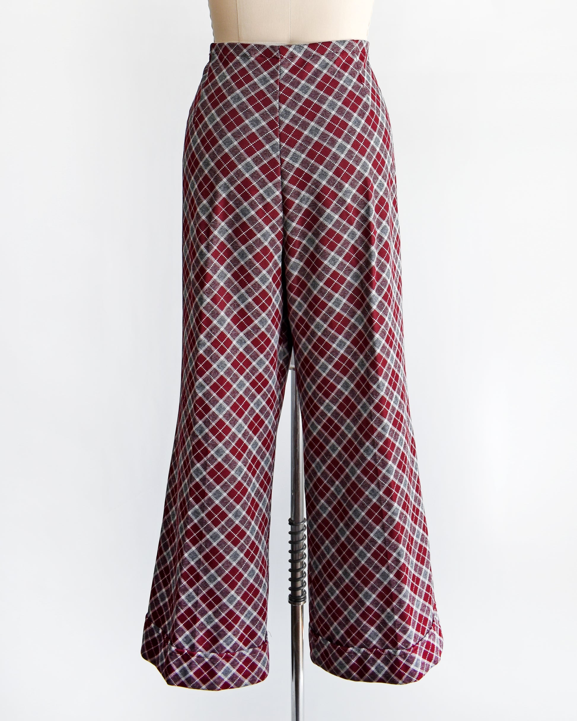 back view of a vintage 1970s burgundy plaid bell bottom pants on a mannequin against a white background