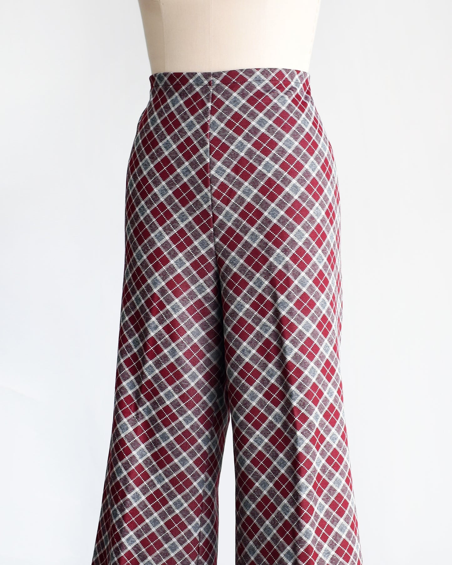 side front view of a vintage 1970s burgundy plaid bell bottom pants on a mannequin against a white background