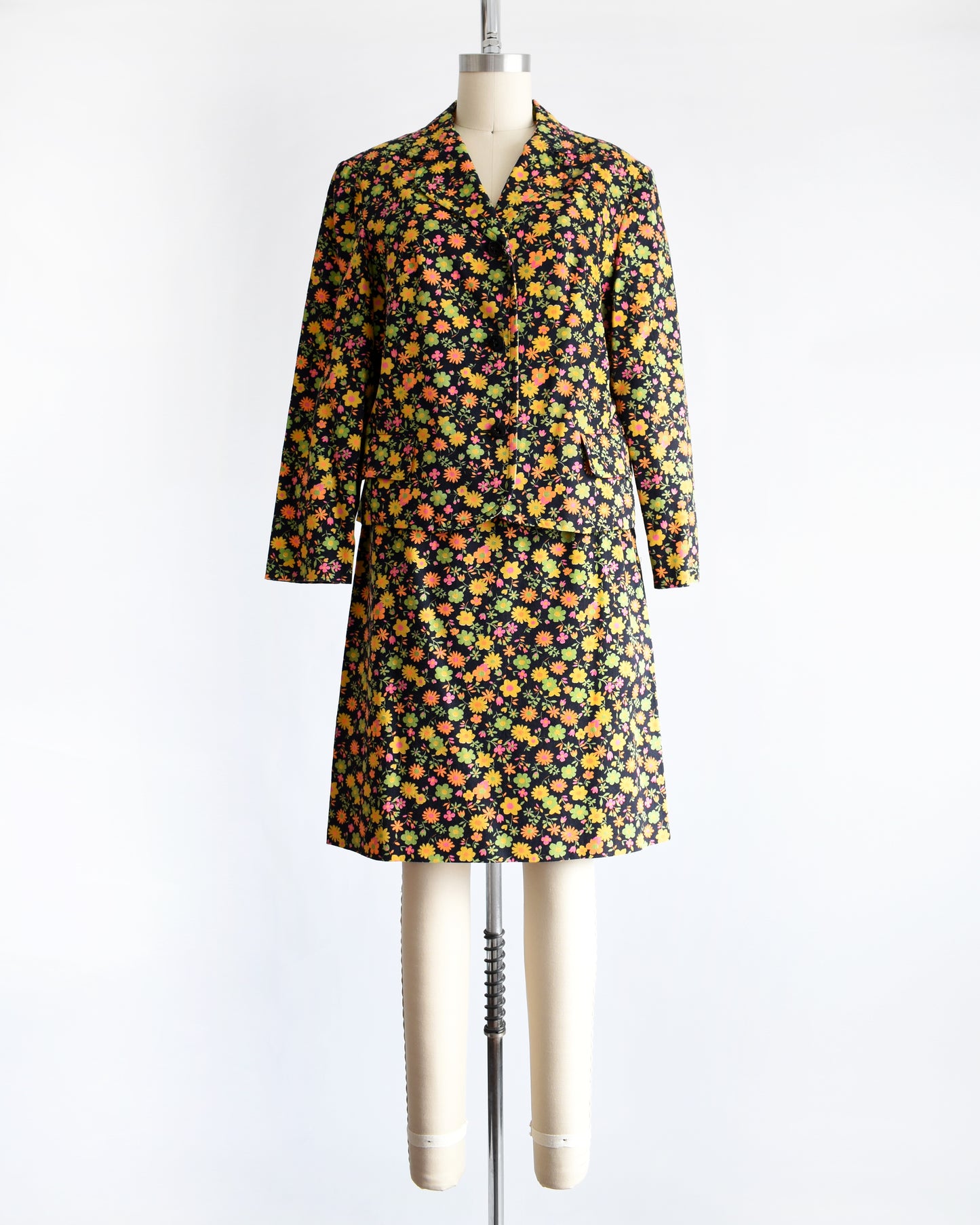 a vintage 1960s/1970s matching floral  blazer and skirt on a mannequin against a white background