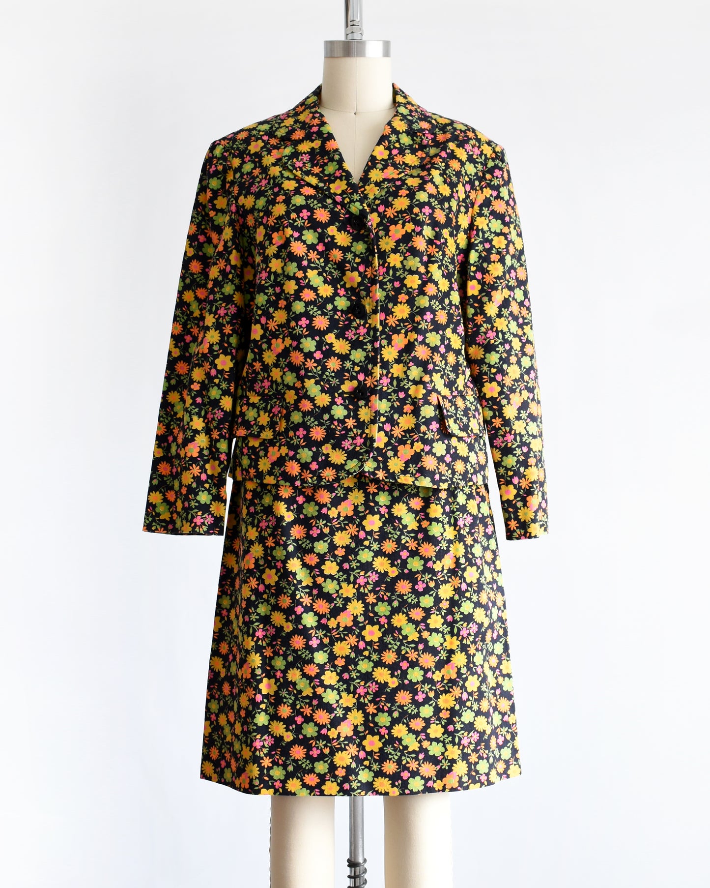 a vintage 1960s/1970s matching floral  blazer and skirt on a mannequin against a white background